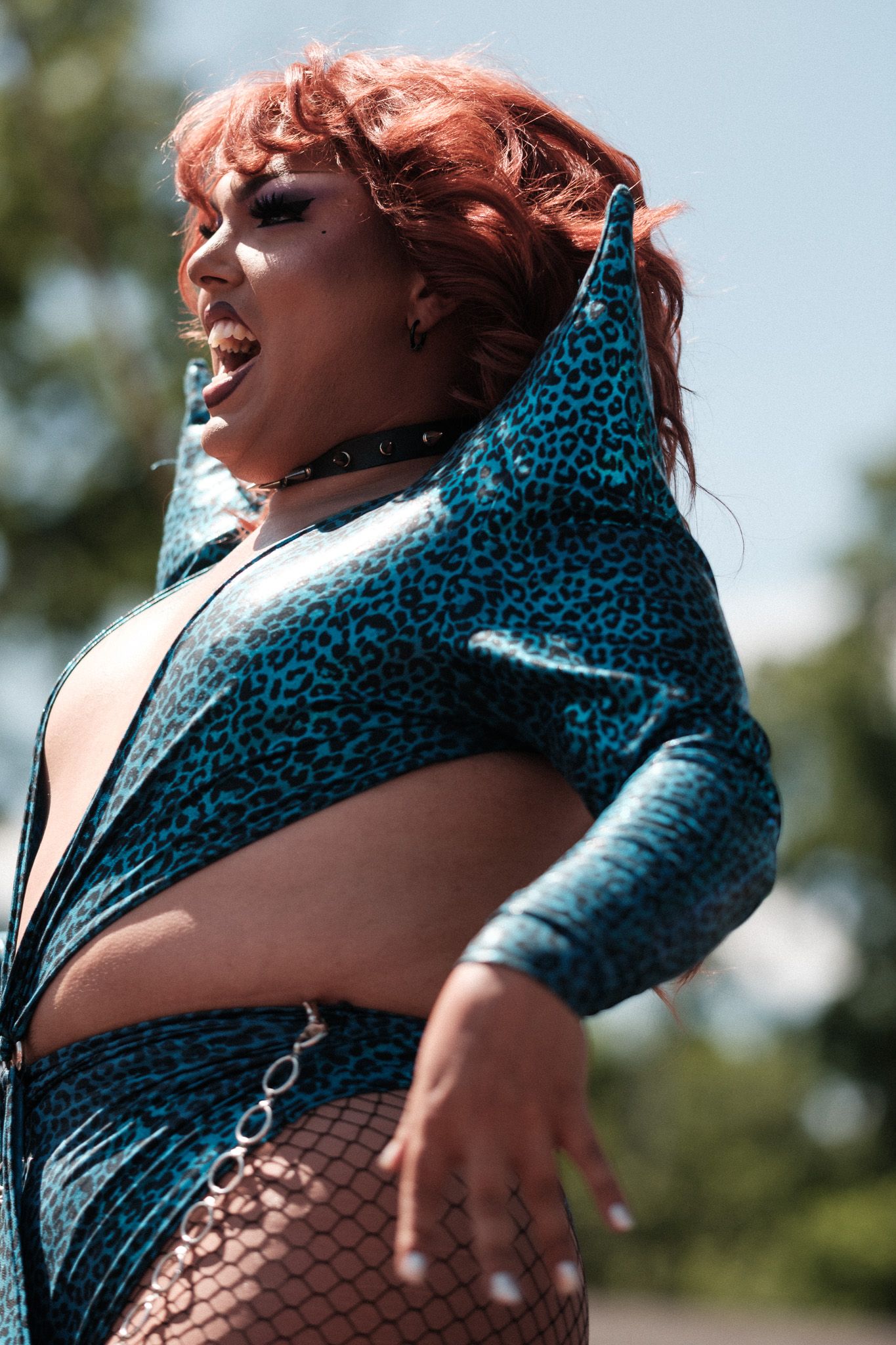 Sequential photos of a performer in a turquoise leopard print outfit striking dramatic poses outdoors.