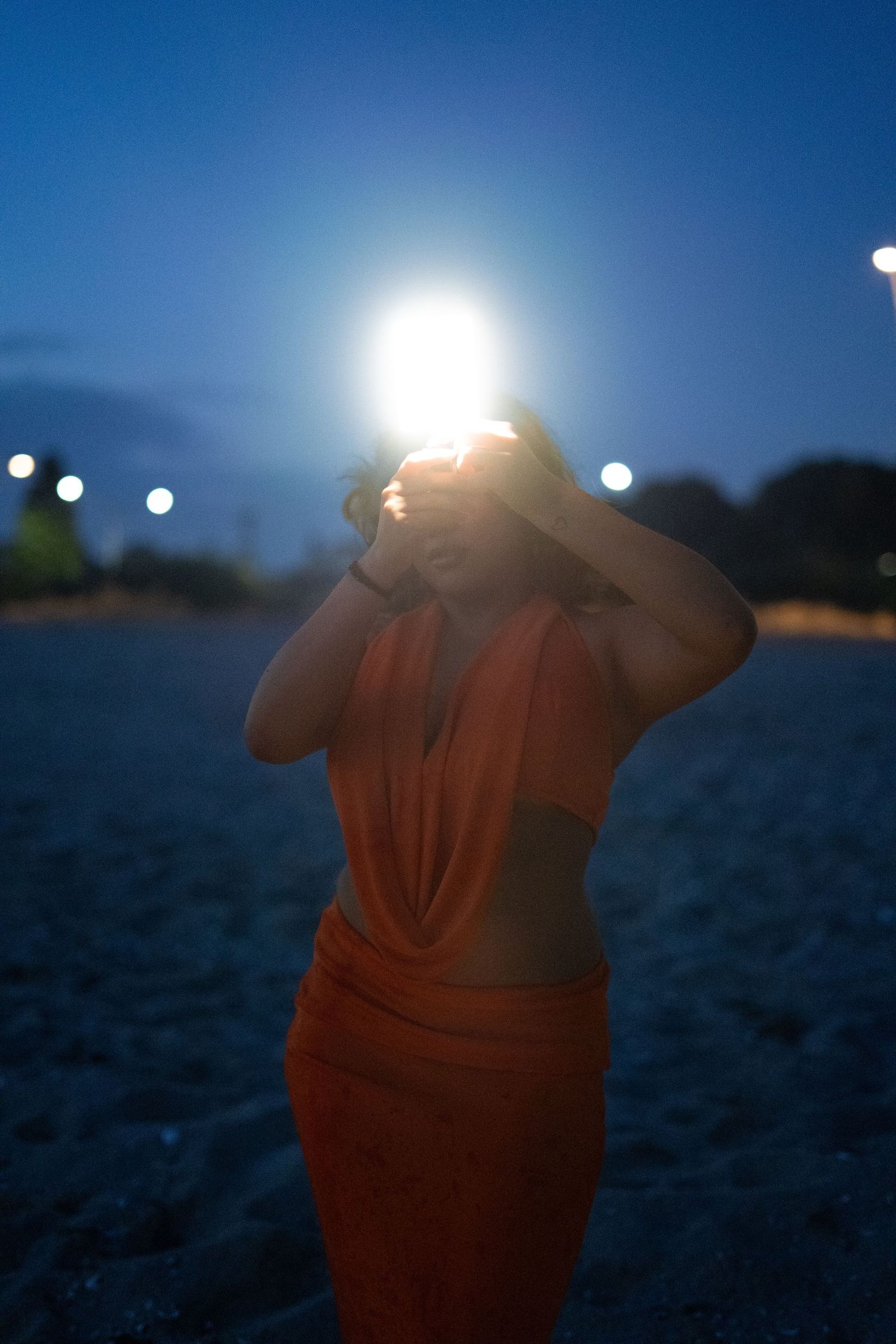 Silhouette against deep blue twilight sky with bright lights creating dramatic atmosphere.