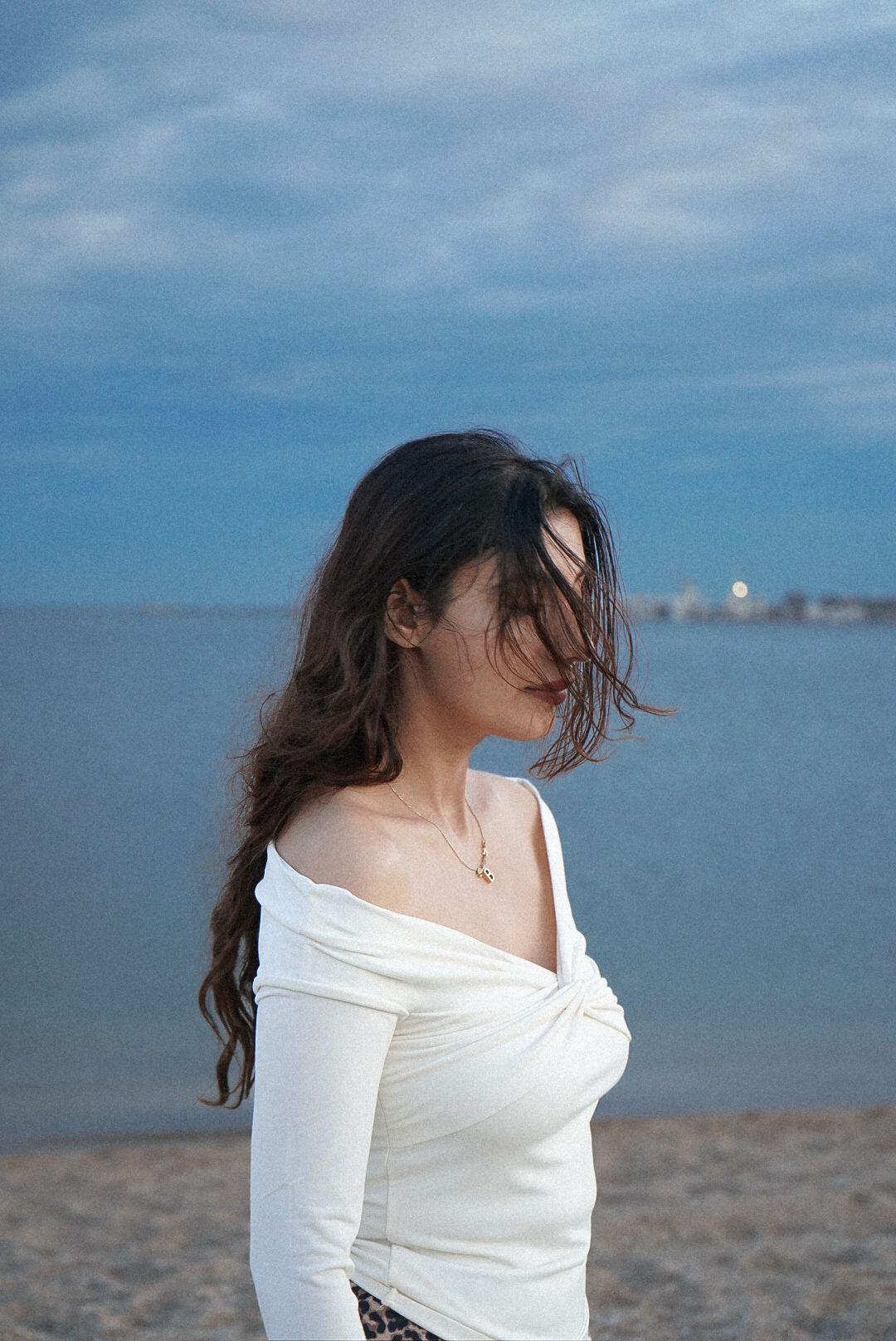 Series of beach portraits with someone in white off-shoulder top against blue sky and ocean.