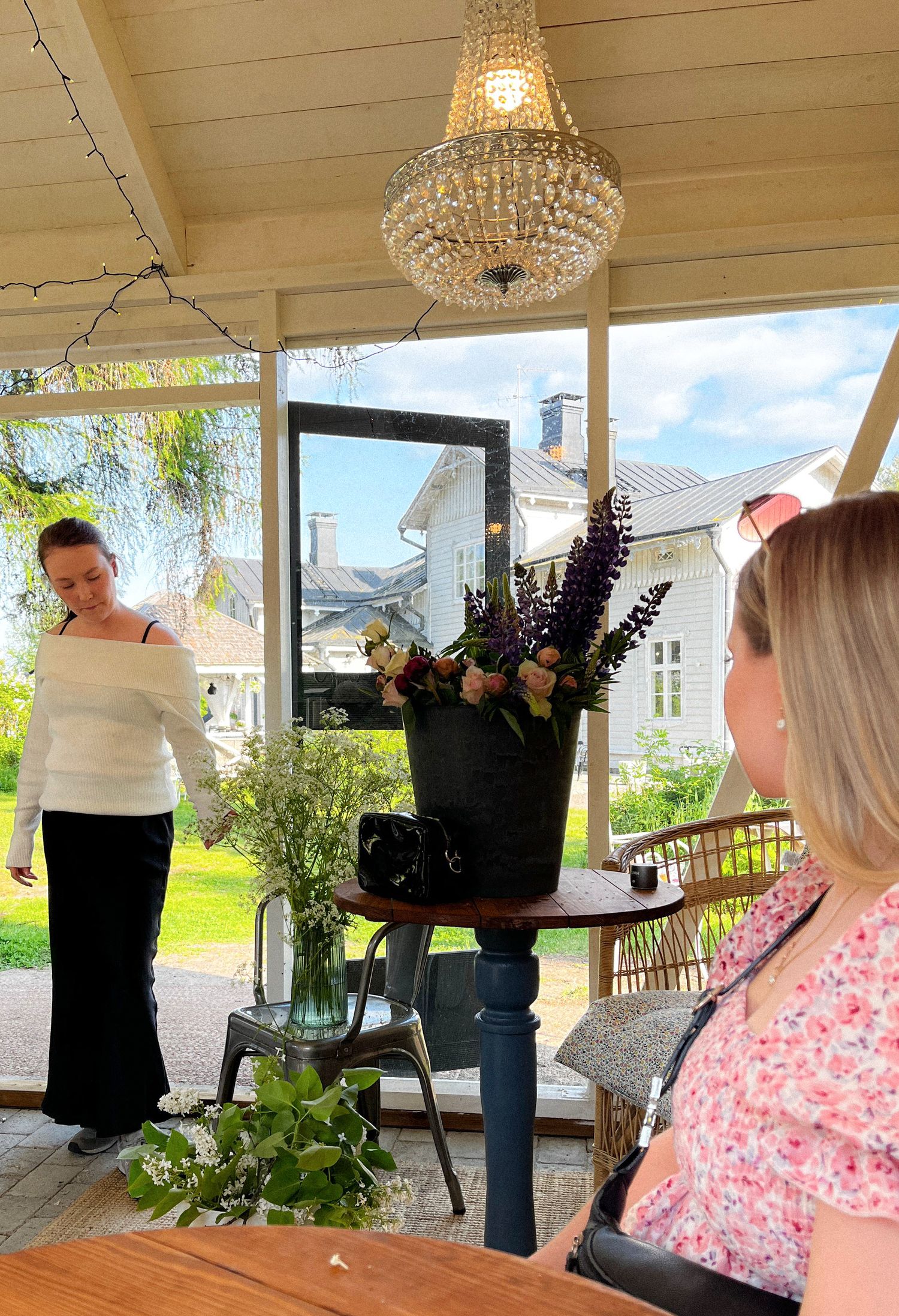 Three connected images show activity on a covered porch with people and decor including a chandelier and floral arrangements.