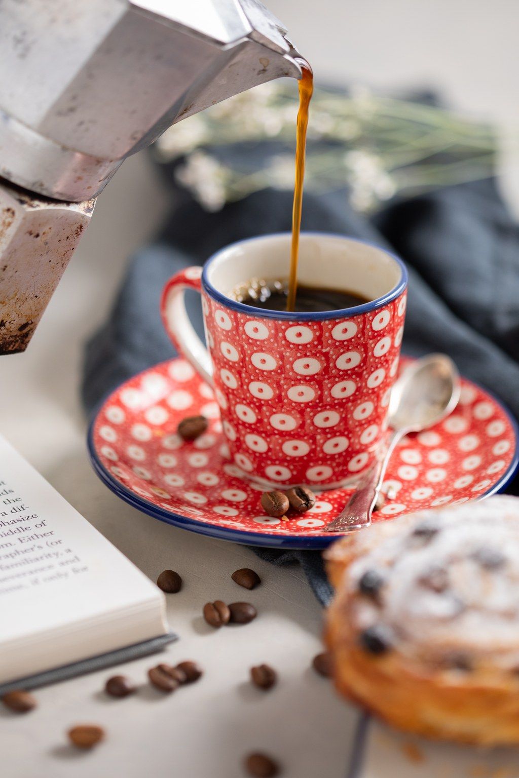 Coffee pouring into a red and white polka dot teacup with matching saucer in a series of four action shots.