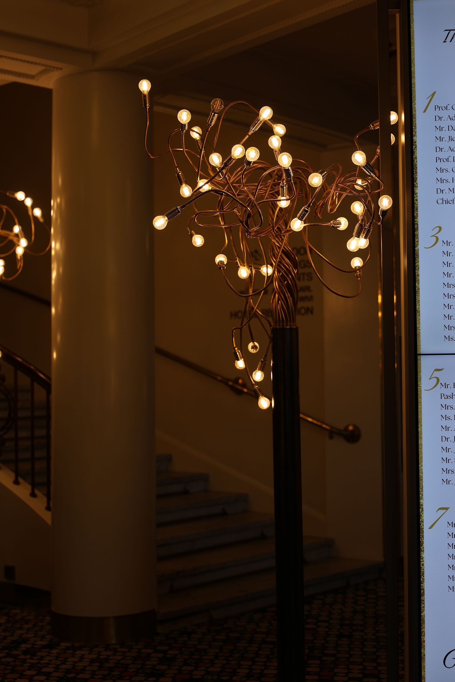 Decorative light fixtures with glowing orbs create a warm ambiance along a dark hallway interior.