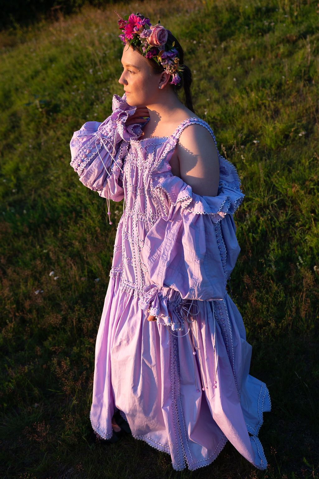 Dreamy outdoor portrait series showing someone in a flowing pink vintage dress and floral crown at golden hour.