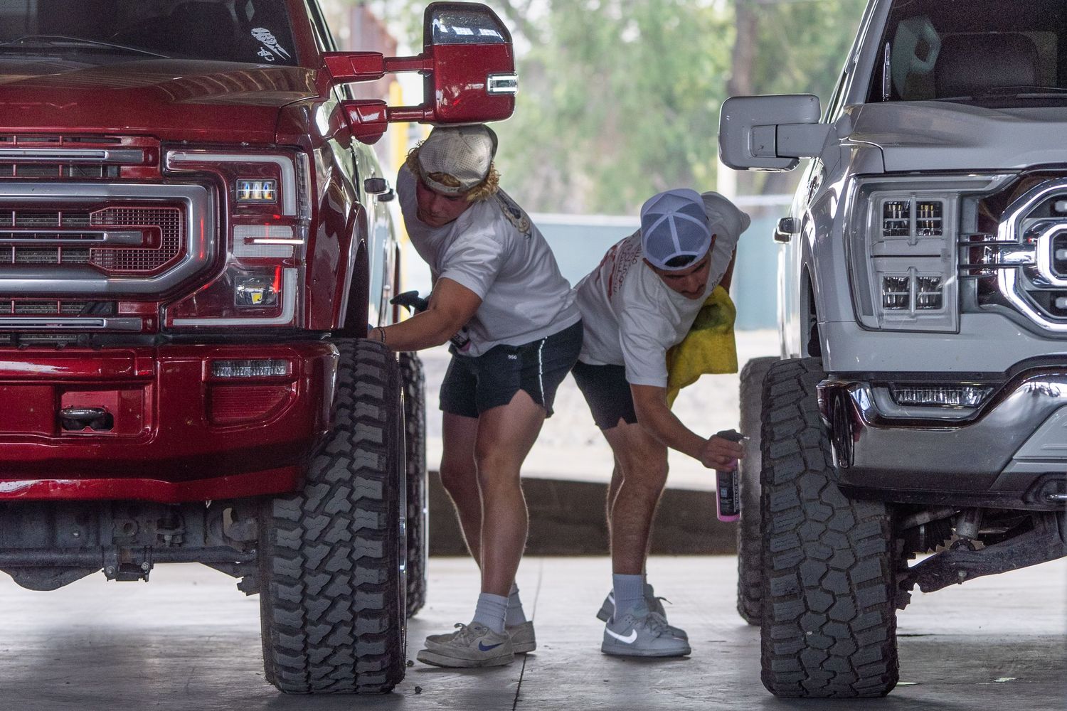 Owners cleaning their custom trucks on display during Idaho Truck Invasion