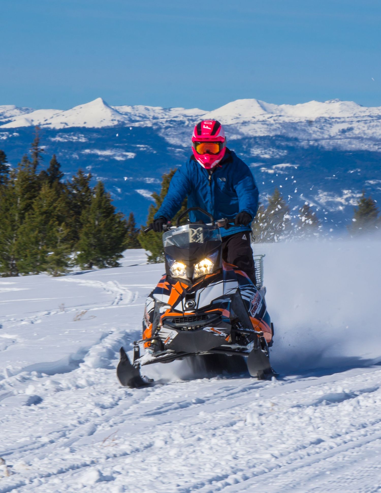 Snowmobiler riding through deep snow in the Idaho mountains