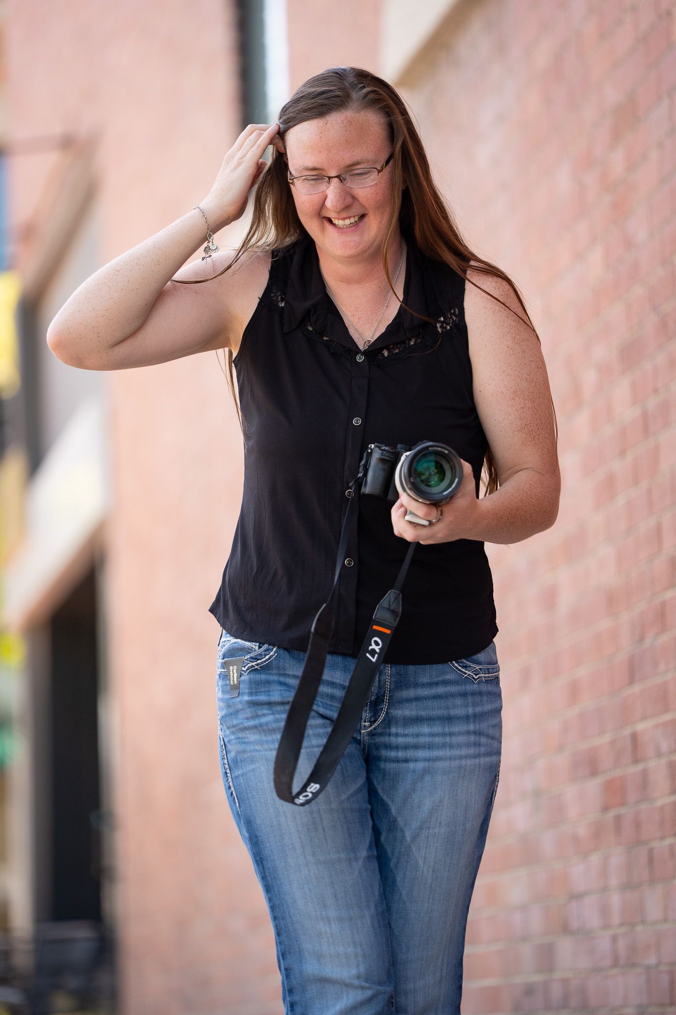 Carlleen of Double C Photography walking with her camera during a branding session in Idaho