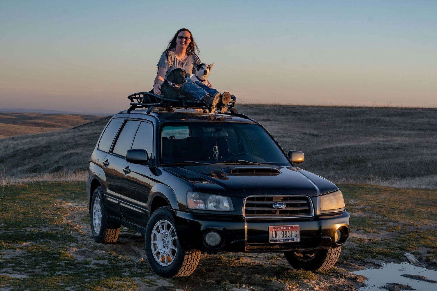 Carlleen sitting atop her Subaru Forester during an outdoor adventure in Idaho