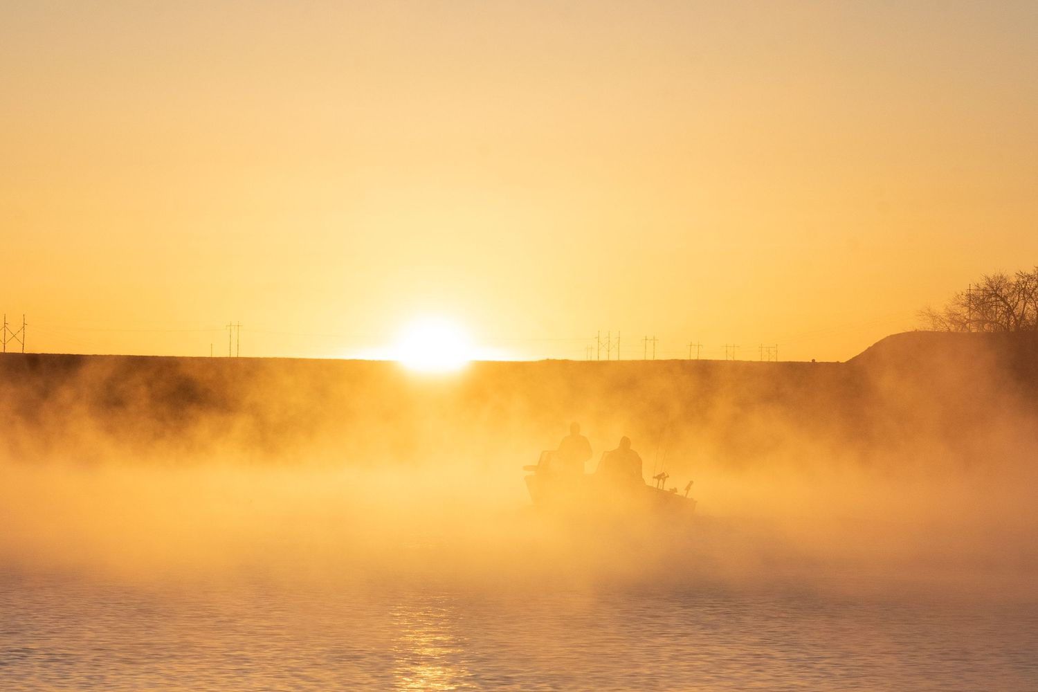 Fishing boat on C.J. Strike Reservoir at Sunrise glowing through mist over C.J. Strike Reservoir during the Crappie Classic in Idaho