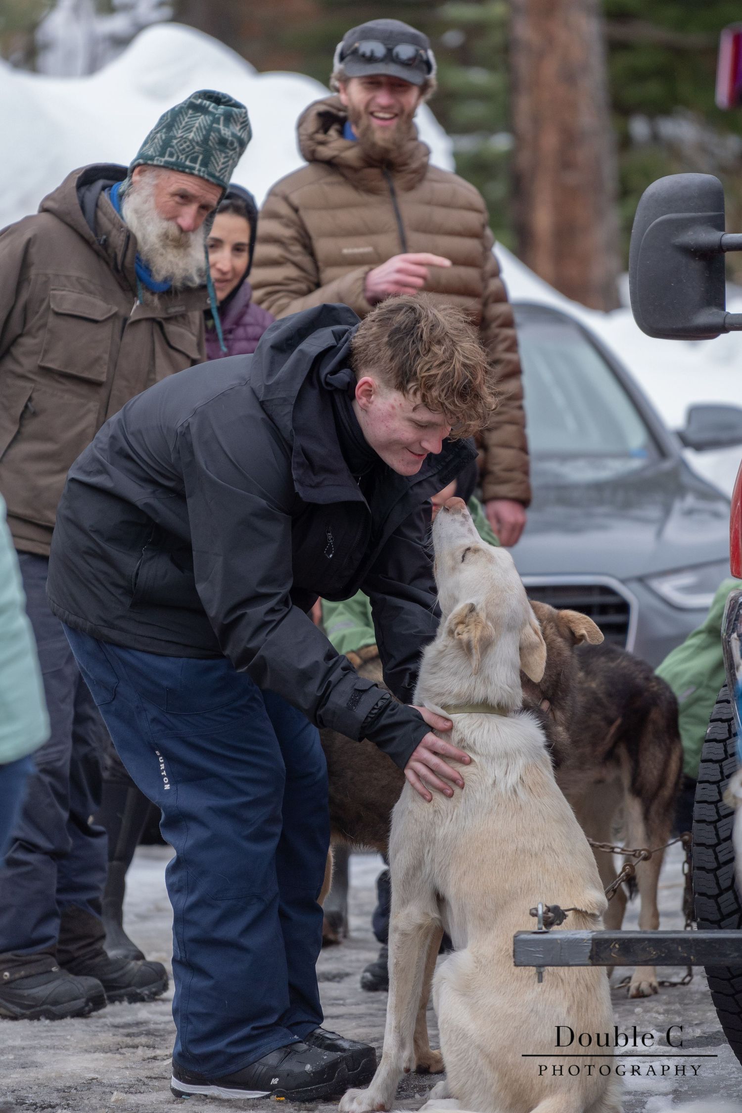 Attendee greeting a sled dog during a meet-the-mushers gathering in Idaho