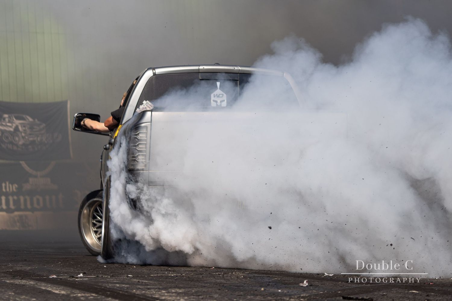 Custom truck performing a burnout through heavy tire smoke during Idaho Truck Invasion