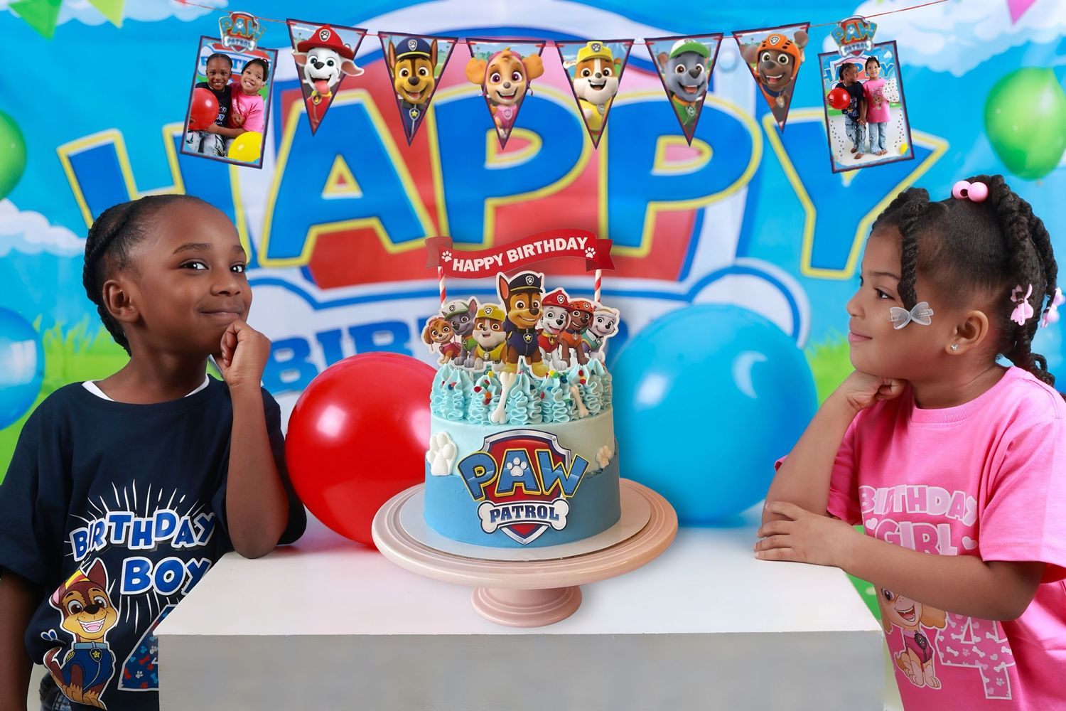 Two children celebrate a Paw Patrol birthday party with a decorated cake and colorful balloons.