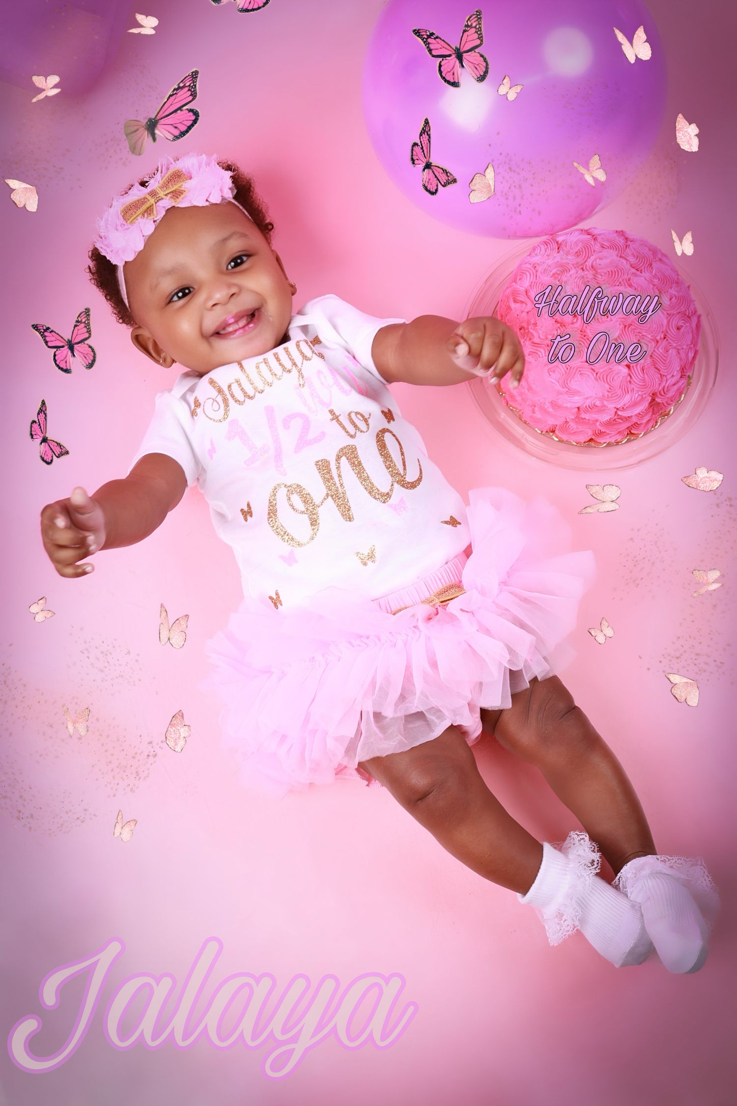 Baby girl Jalaya in pink tutu celebrating half birthday with butterfly themed pink backdrop.