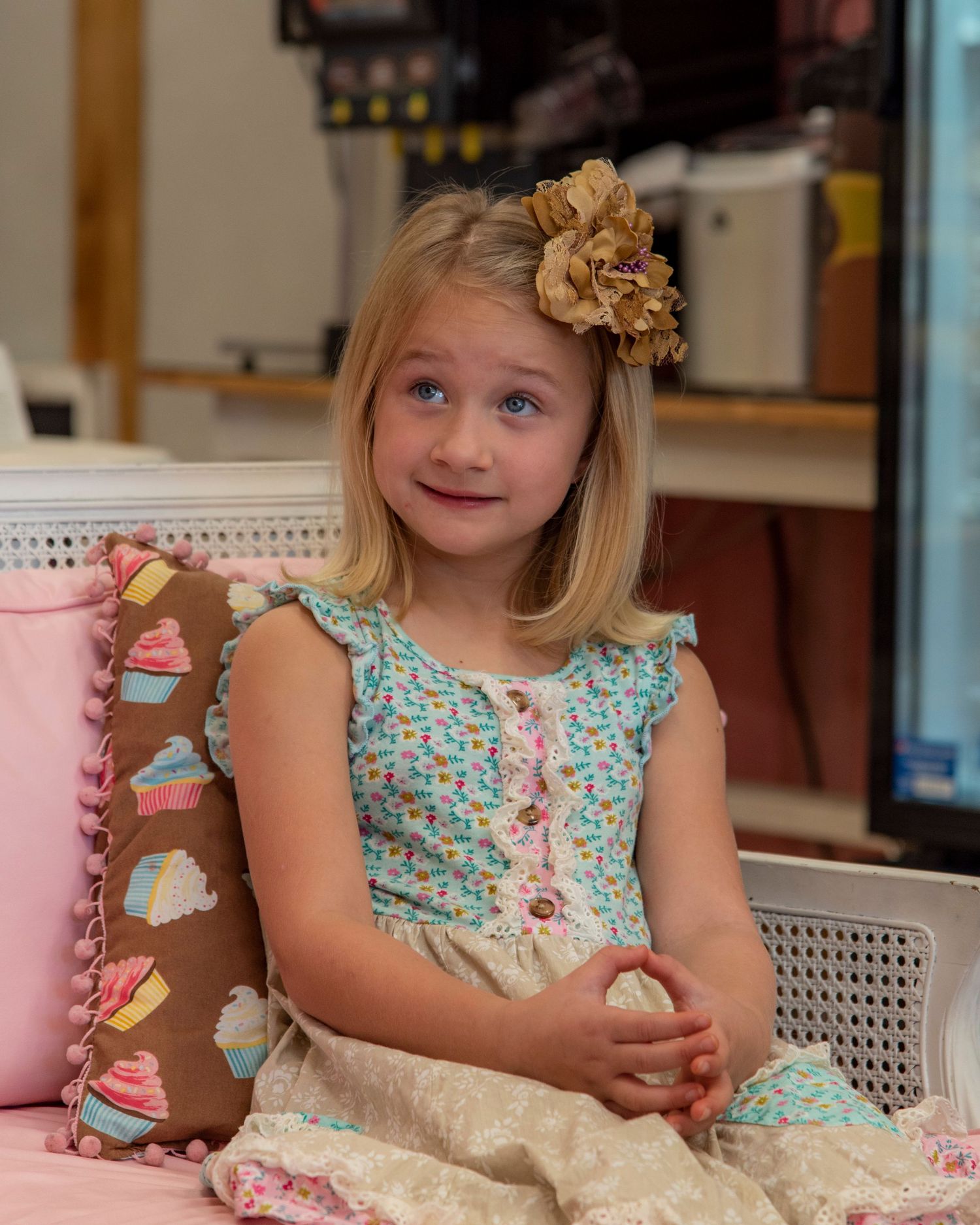 young girl posing seated with large bow in her hair