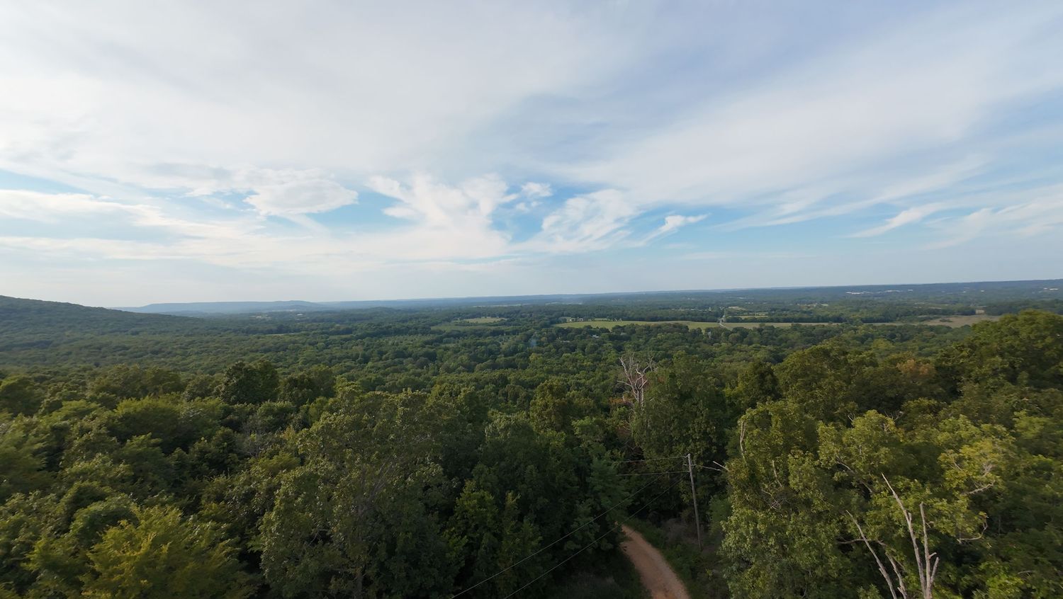 horizon of forest with cloudy sky as seen from a drone