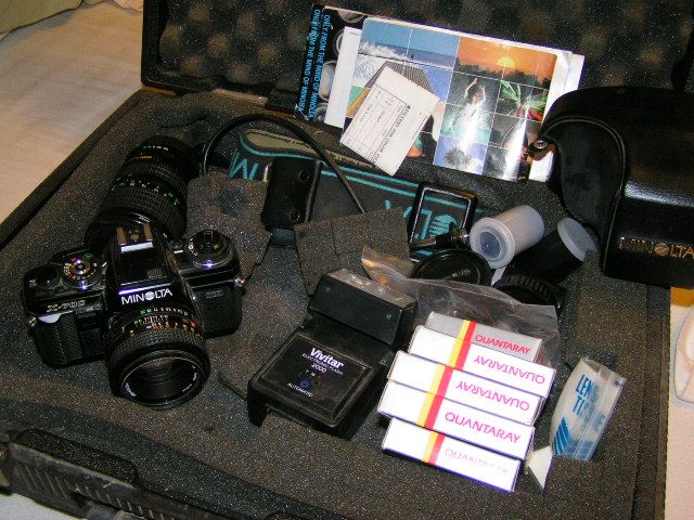 Open travel case with a camera and photography gear displayed inside.