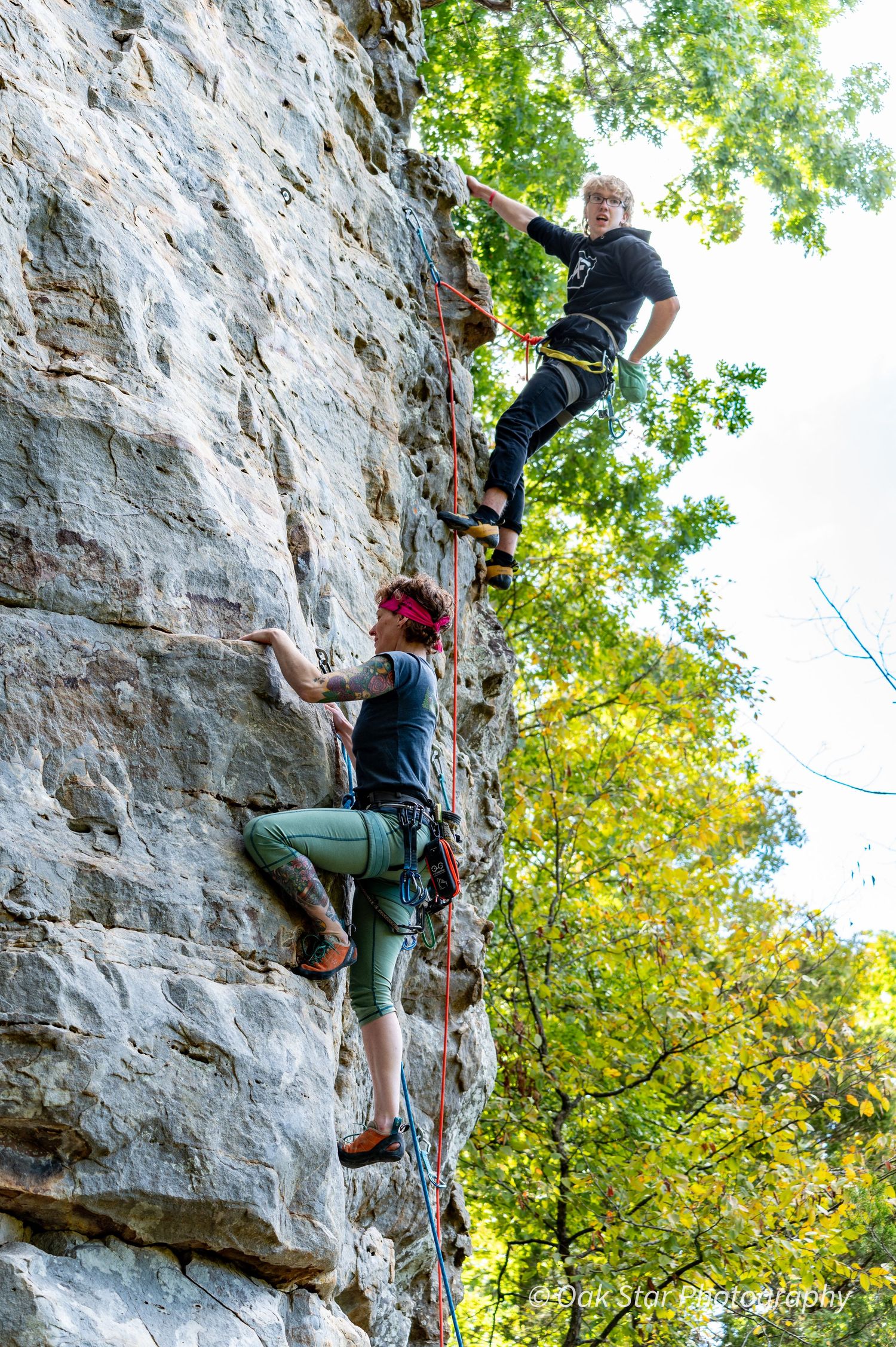 Rock climbers ascending a rock cliff.