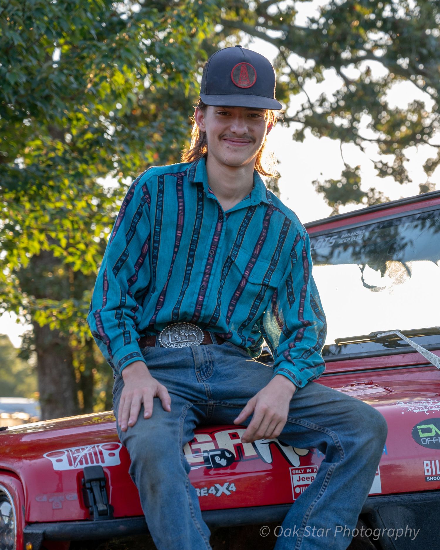 young man sitting on the hood of a Jeep