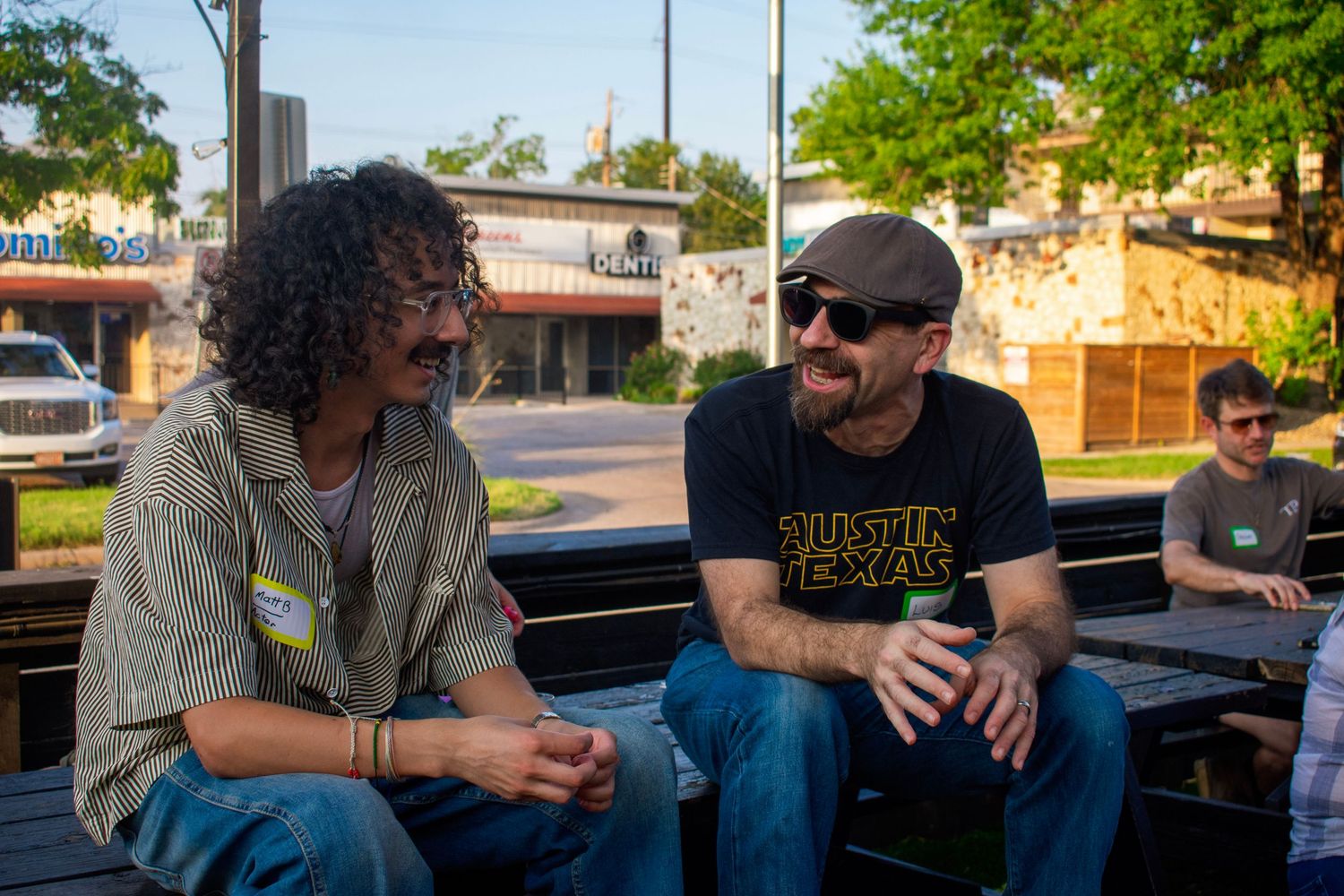 Two attendees chat at an outdoor community event, captured by a Texas event photographer.