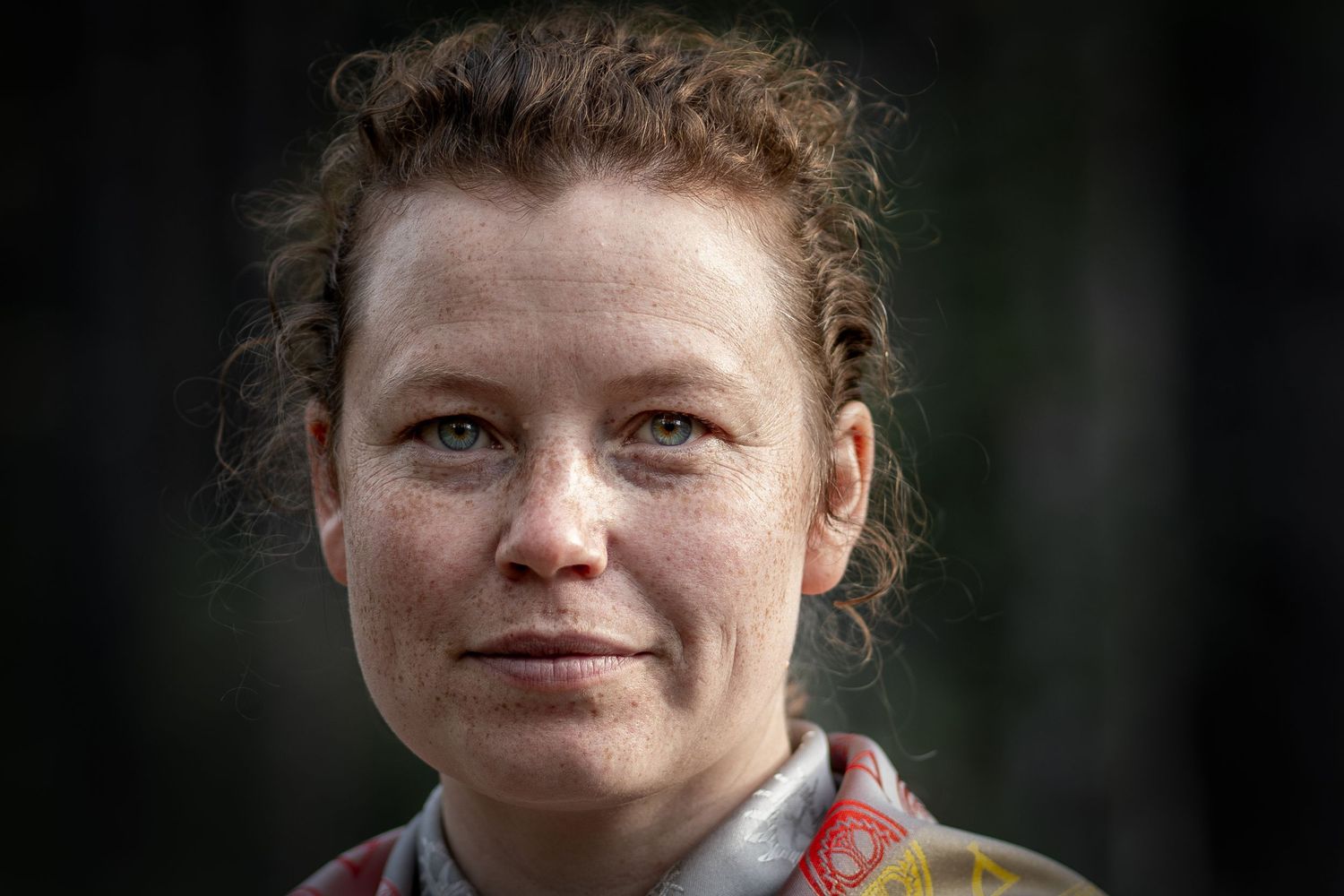 A series of close-up portrait photos showing someone with curly red hair and freckles against a dark background.