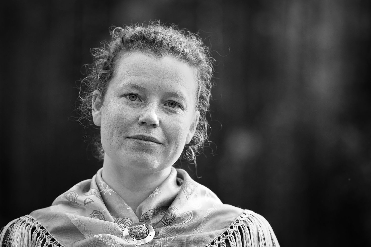 Black and white portrait with traditional Nordic or historical costume and pulled back hair.