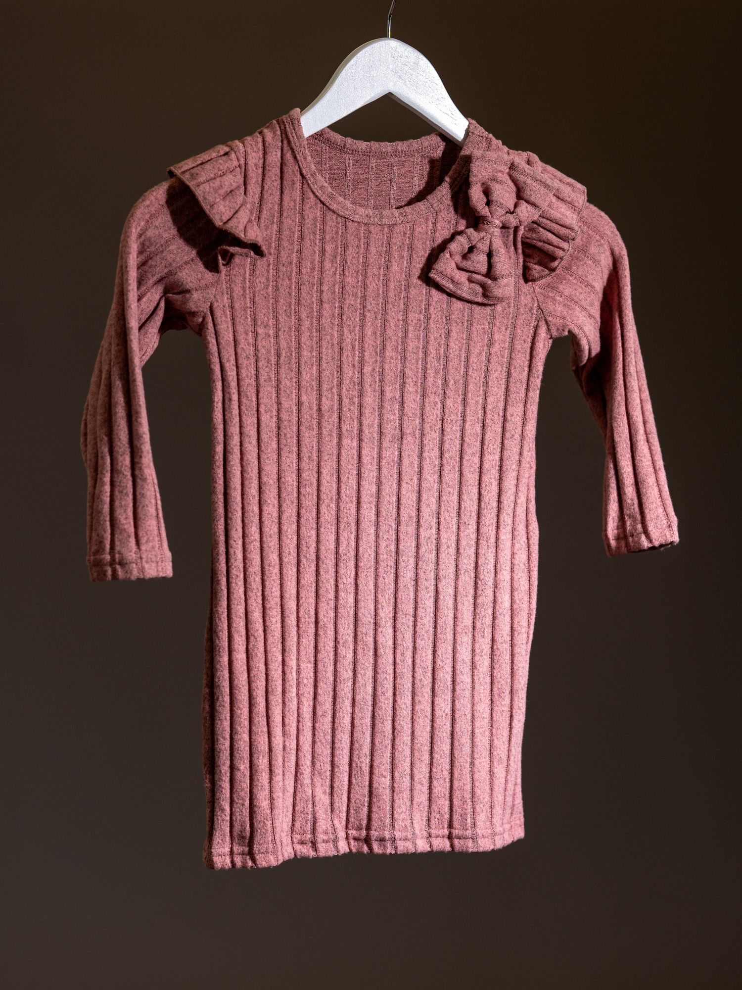 Dammig rosa ribbad tröja med långa knutna ärmar visad från flera vinklar mot en mörk bakgrund.