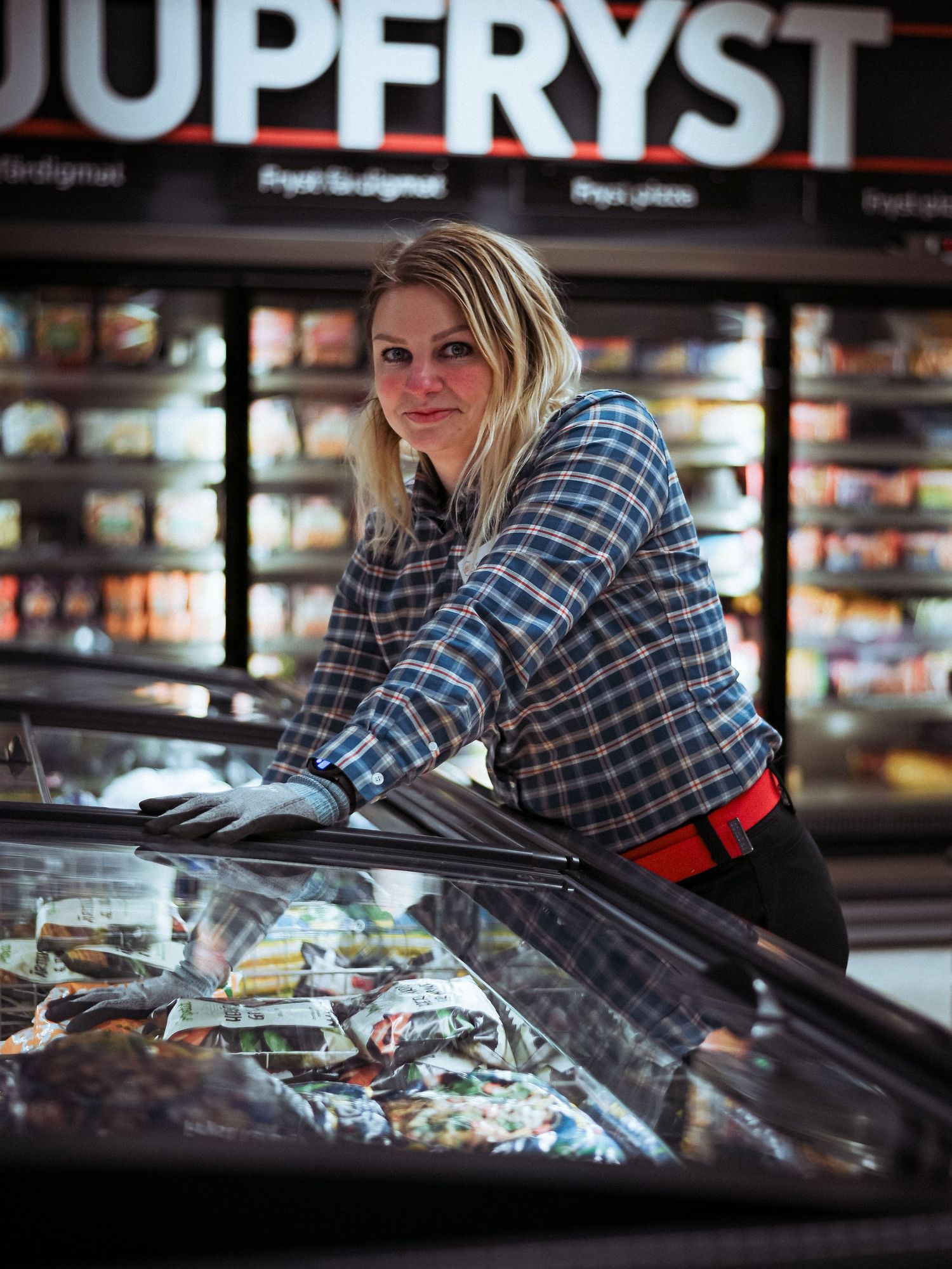 Someone browses through products in a retail display case at a store with black shelving units.