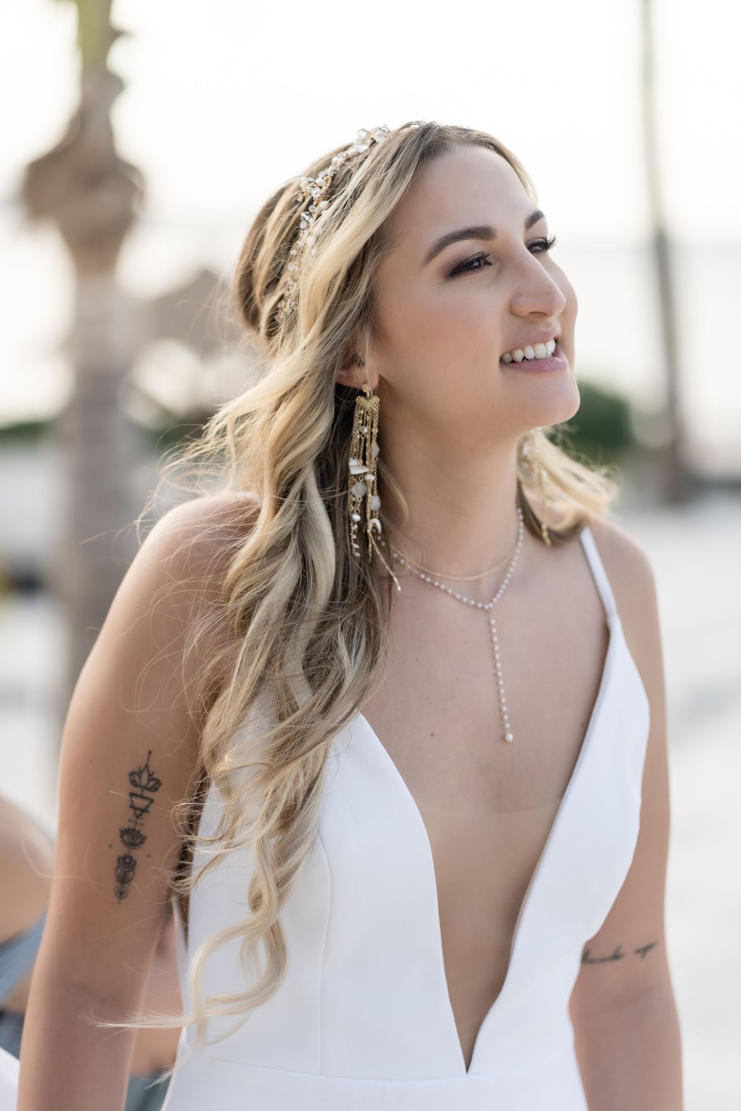 Bride in plunging neckline dress with ornate headpiece and blonde waves.