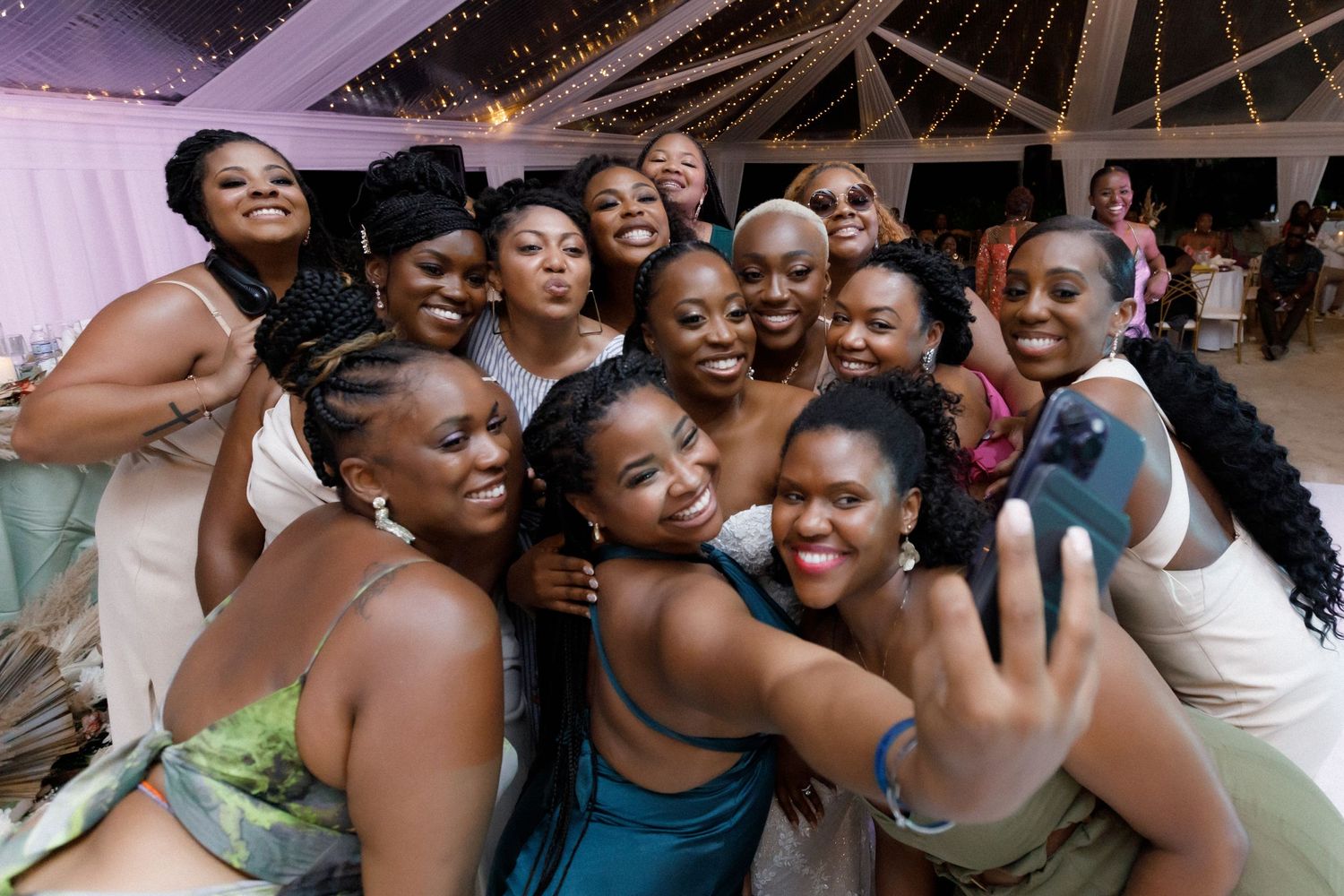 Wedding guests pose together for a joyful group selfie during the reception celebrations.