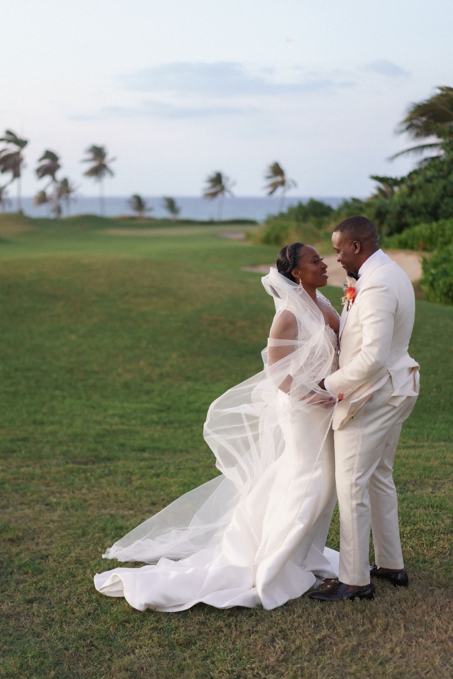 Scenic coastal wedding portrait with palm trees and ocean breeze.