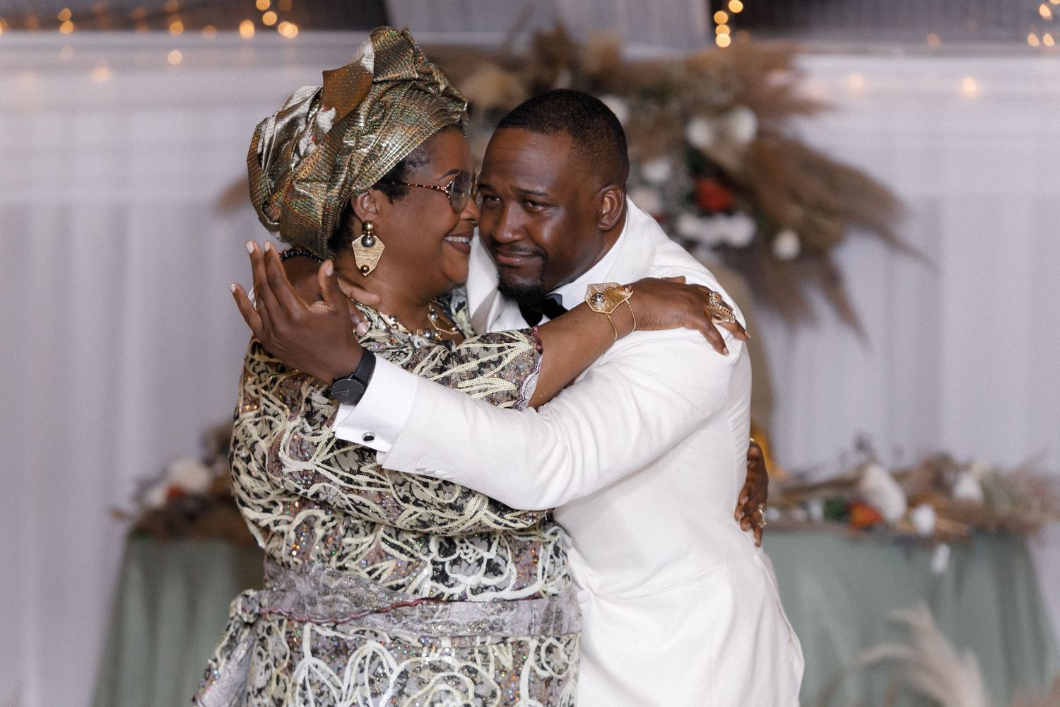 Emotional dance between wedding couple and guest during reception celebration.