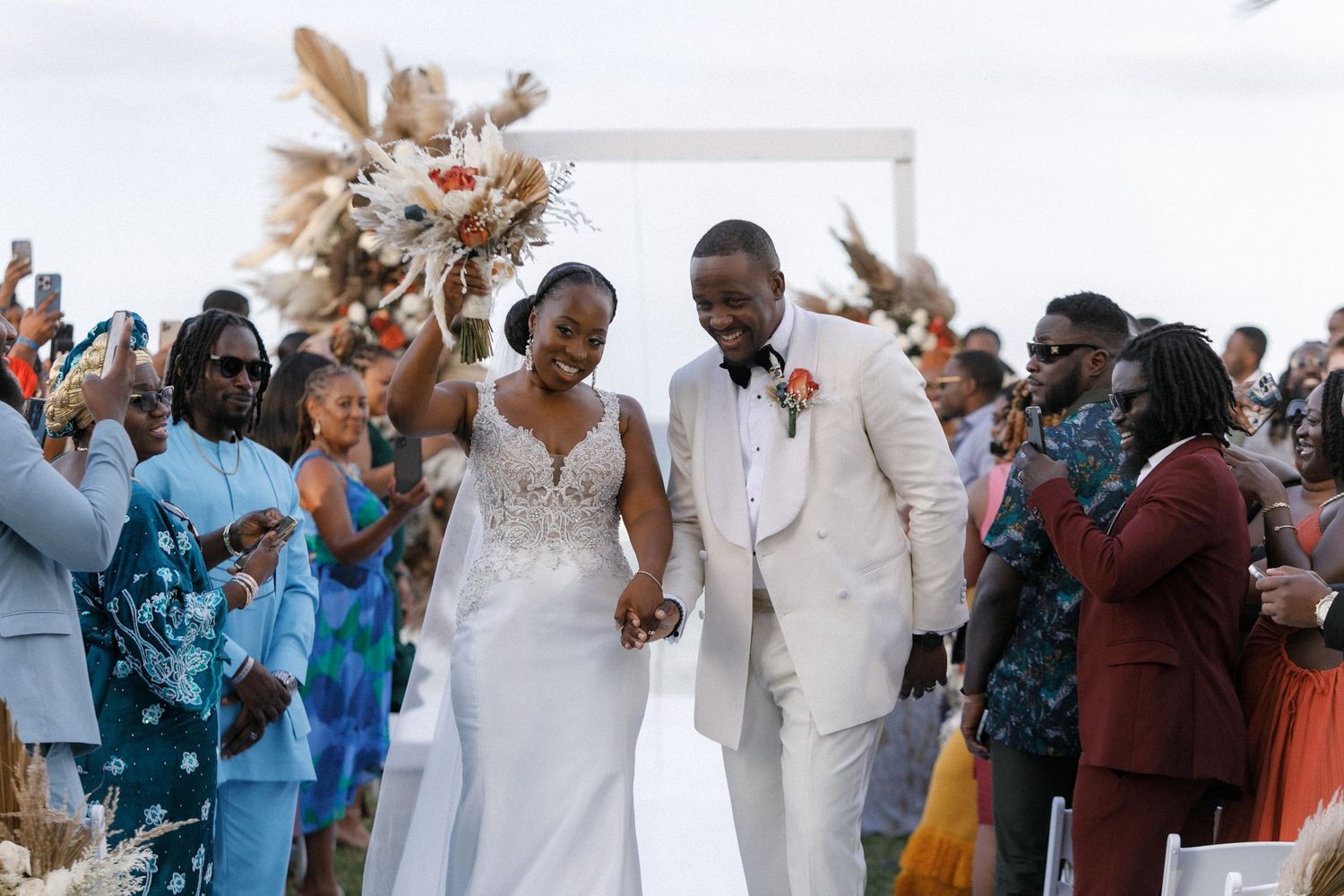 Newlyweds walking down the aisle as wedding guests celebrate their union.