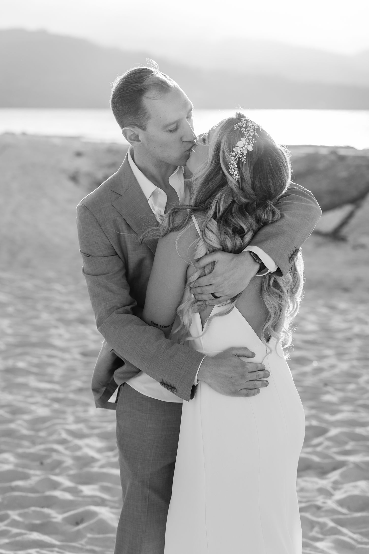 Black and white portrait of a romantic moment on a sandy beach.
