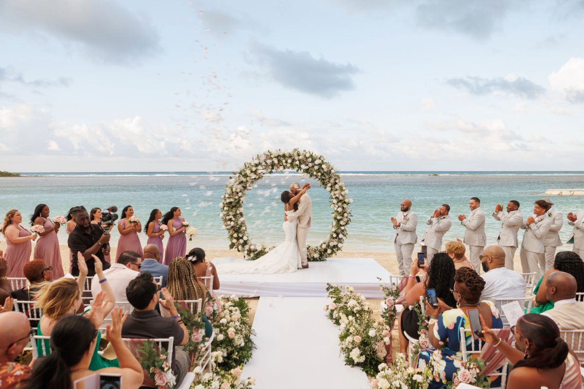 Luxury beachfront ceremony with floral arch and ocean backdrop phootgraphed by wedding photographer in Montego Bay Jamaica Olga Sam