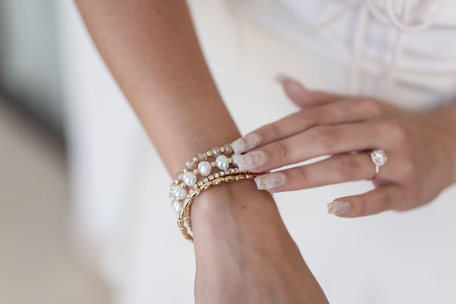 Close up of pearl and crystal bracelets on bride's wrist.