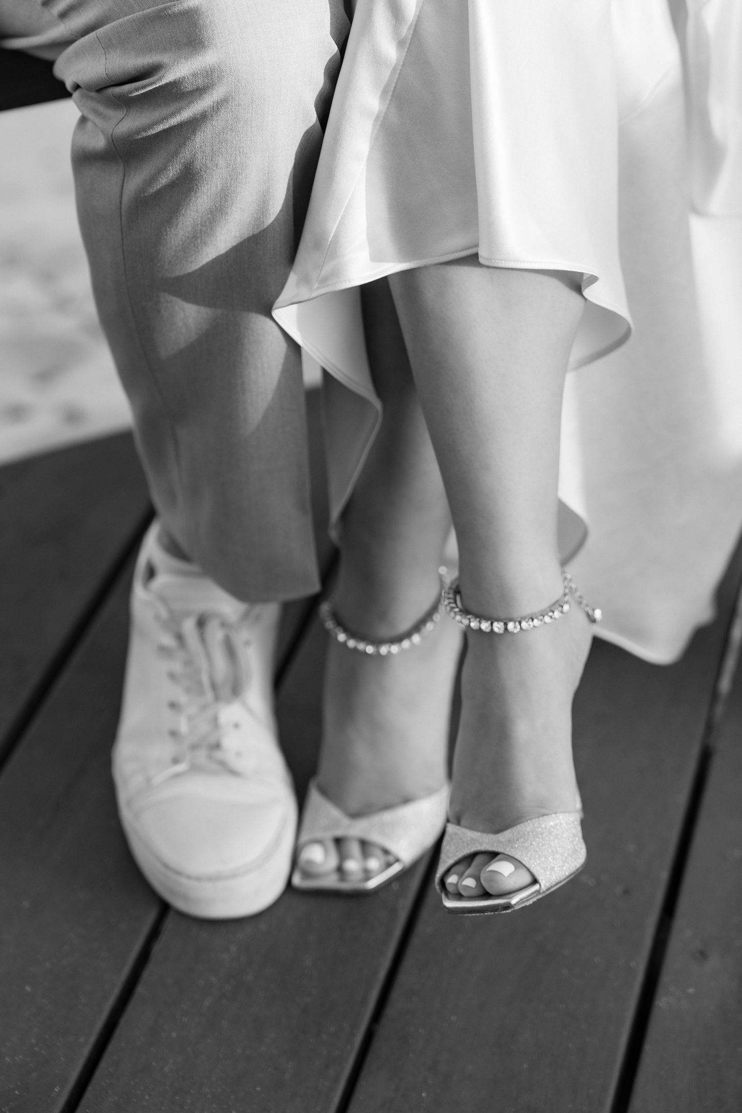 Contrasting footwear at a wedding showing elegant heels and casual sneakers.