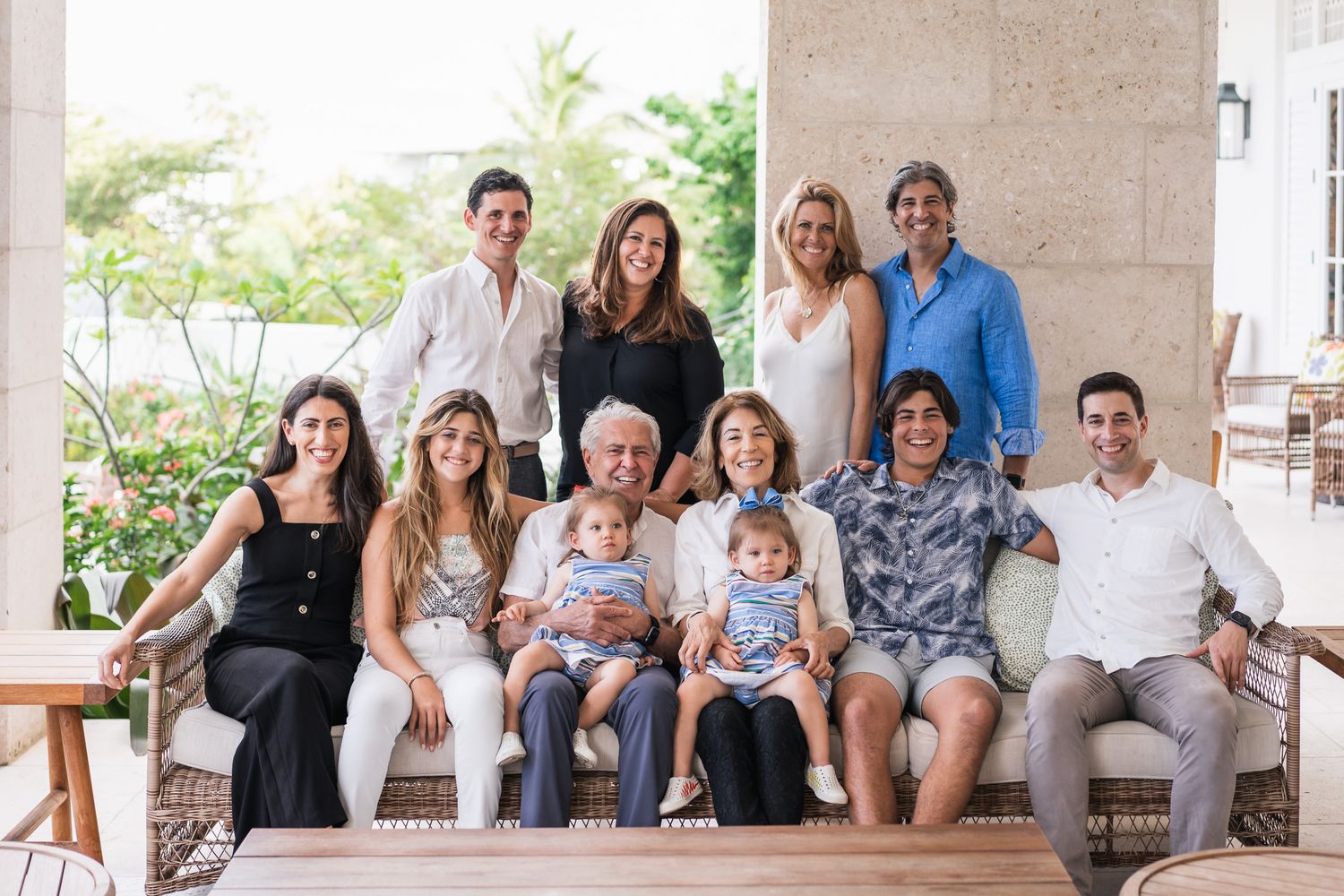 Extended family gathering for a multi-generational portrait on a covered porch.