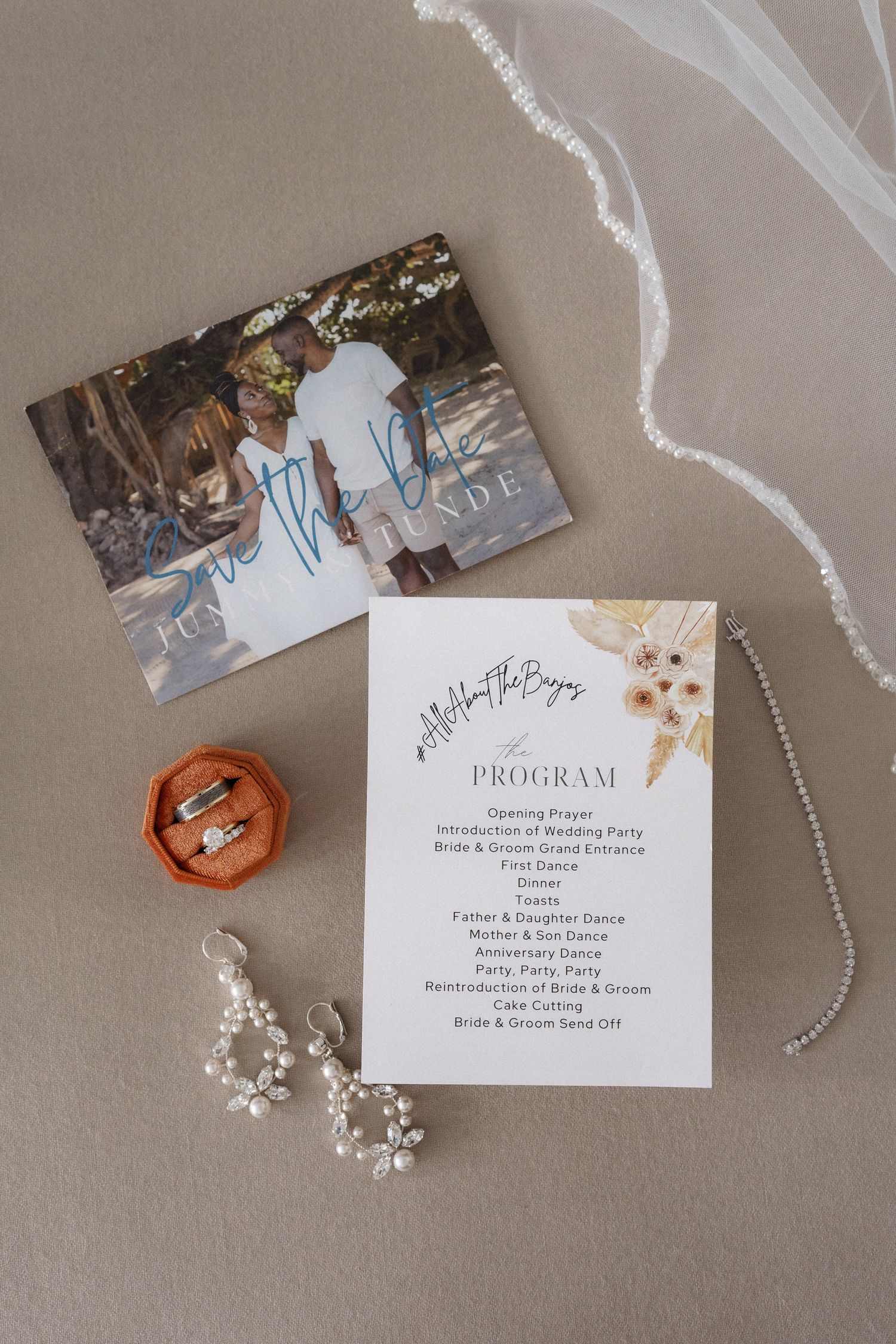 Wedding details including a program card, crystal earrings, and photograph laid on a neutral background.