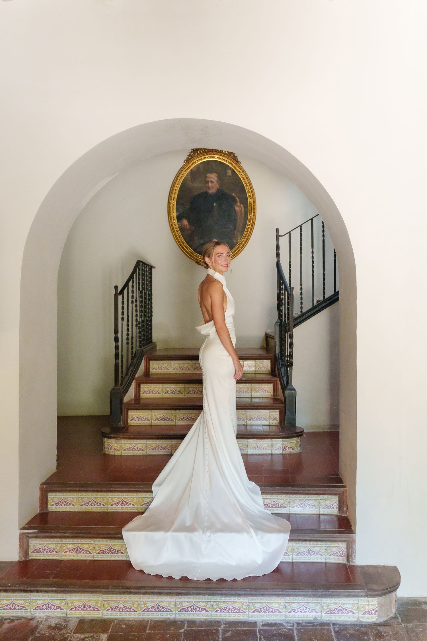 A wedding dress flows elegantly across Spanish-style tiled steps and archways in a series of connected photos.