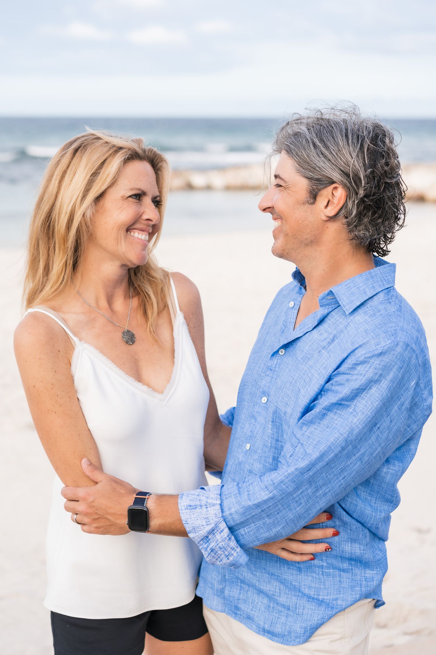 Two people sharing a joyful moment together on a sunny beach.