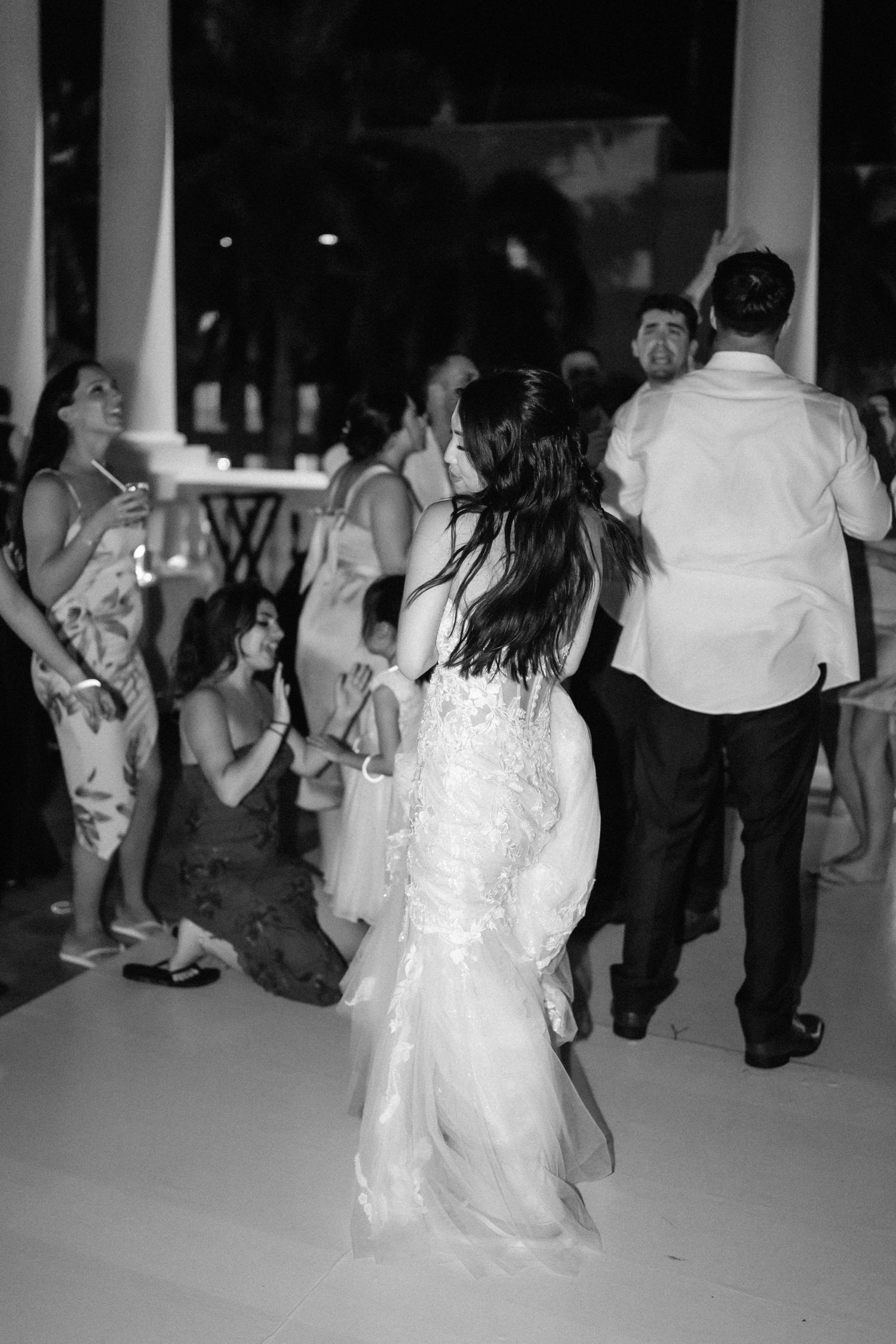 Wedding guests dancing at an outdoor evening reception.