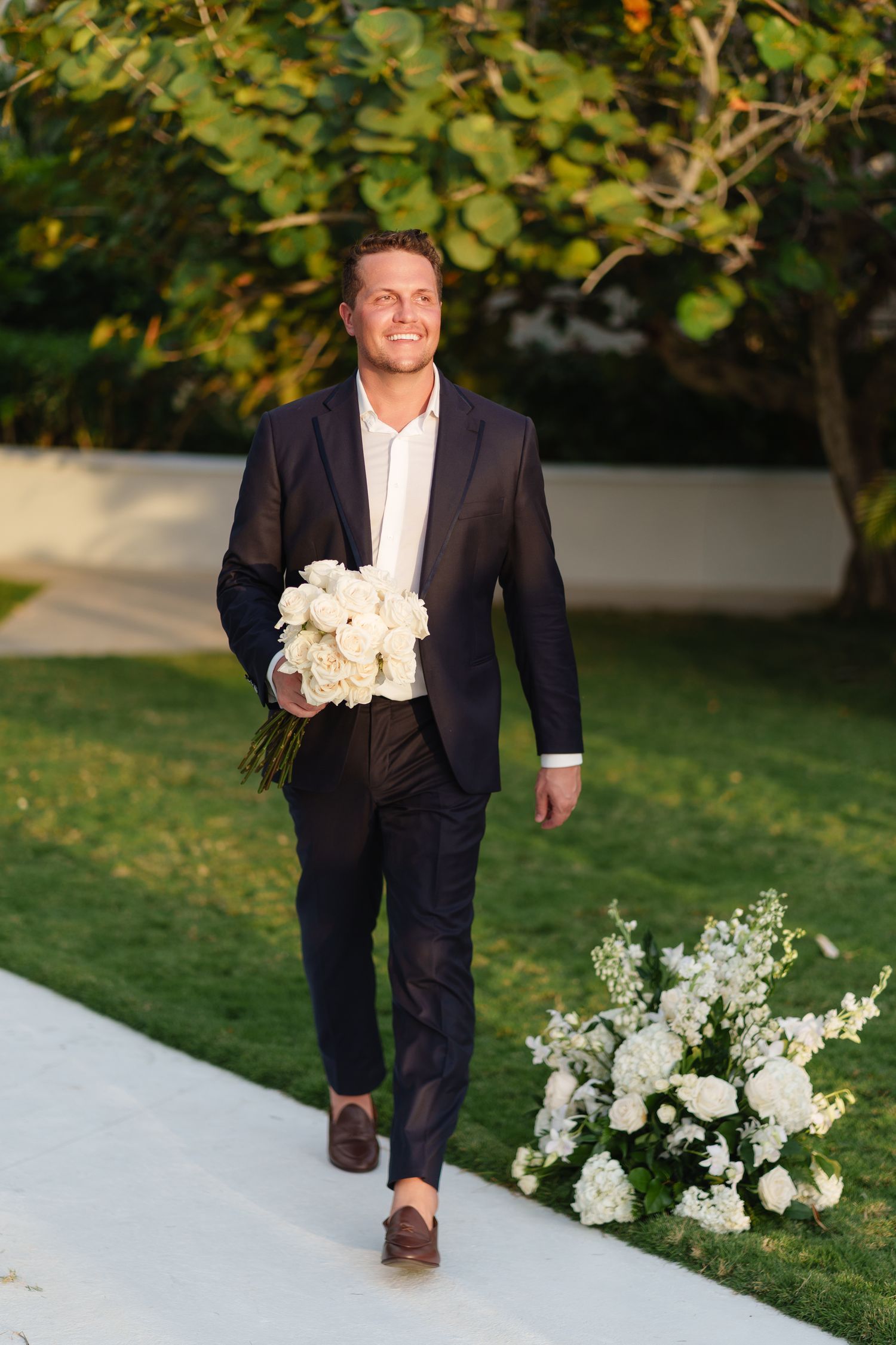 The groom walking with the bridal bouquet photographed by PhotoMagic Jamaica by Olga