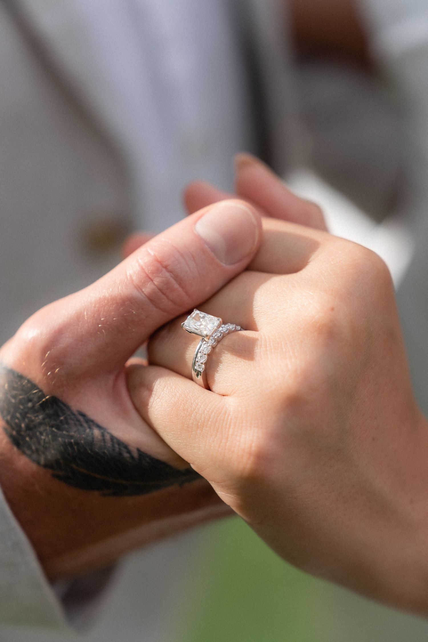 Close-up shot of hands showing diamond engagement ring during wedding ceremony.