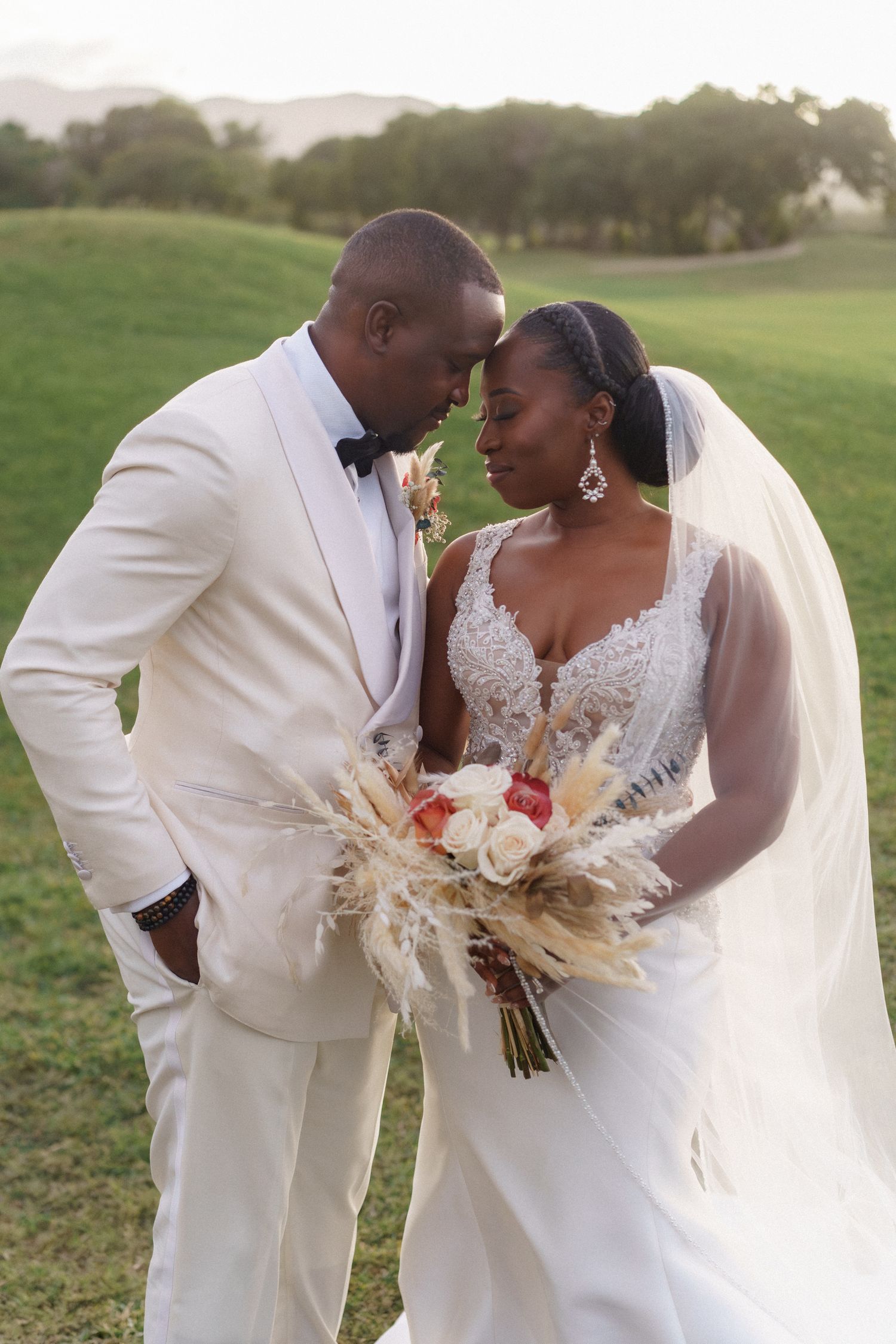 Romantic wedding portrait in a scenic outdoor setting with natural greenery.