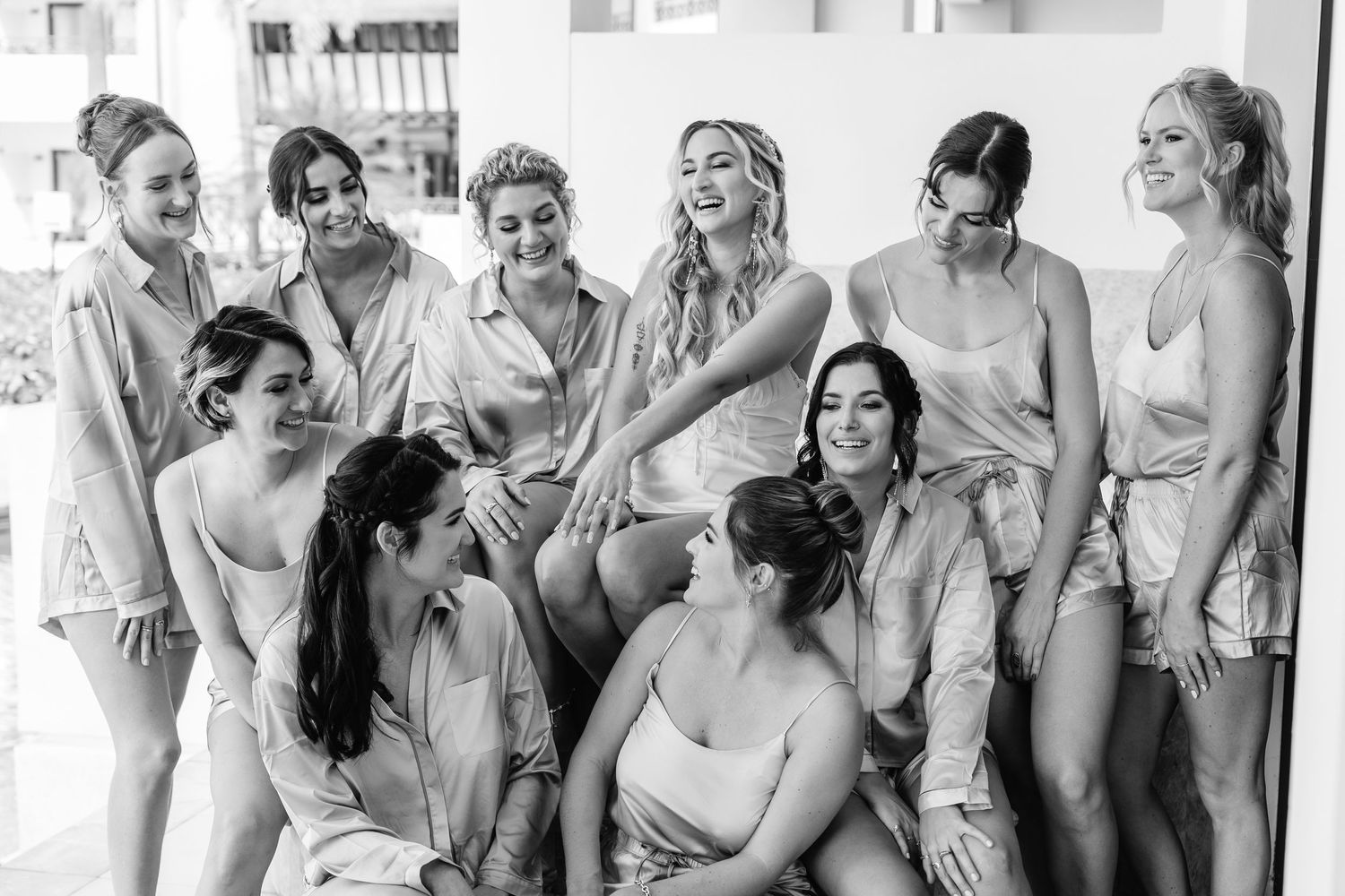 Black and white photo of bridesmaids sharing a candid moment together.