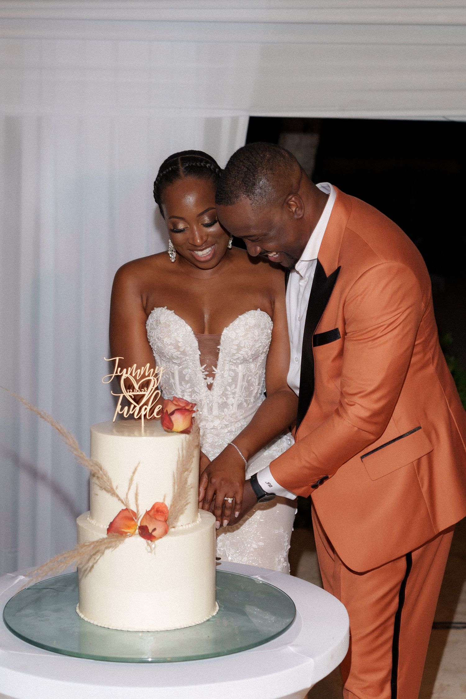Newlyweds cut their elegant white wedding cake together during their reception celebration.