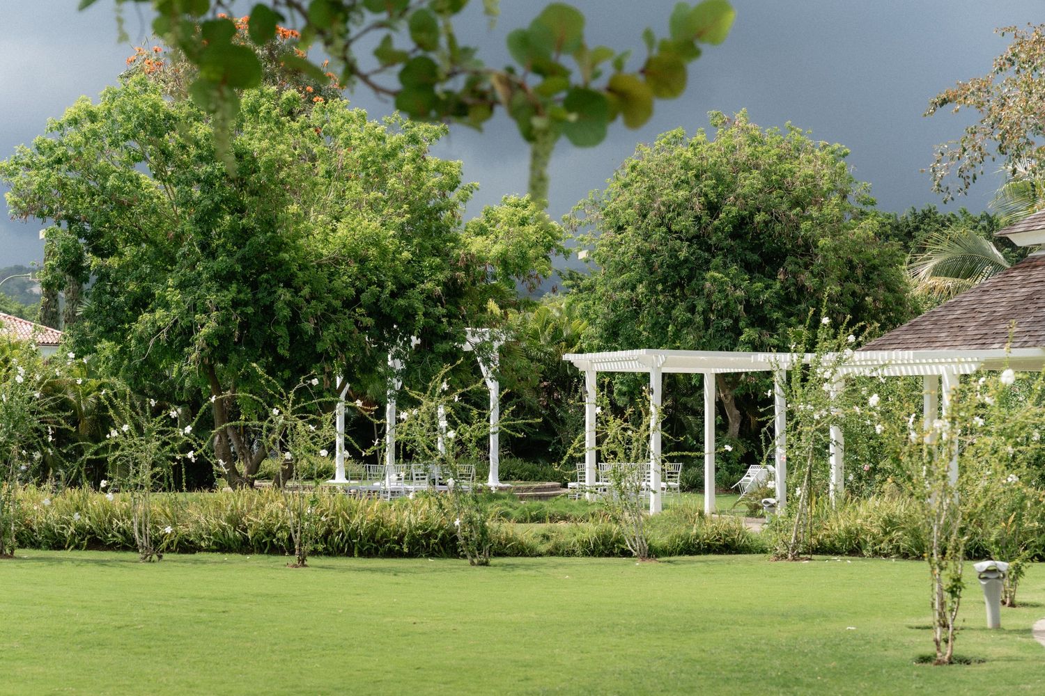 Serene garden landscape with white pergolas and lush greenery.