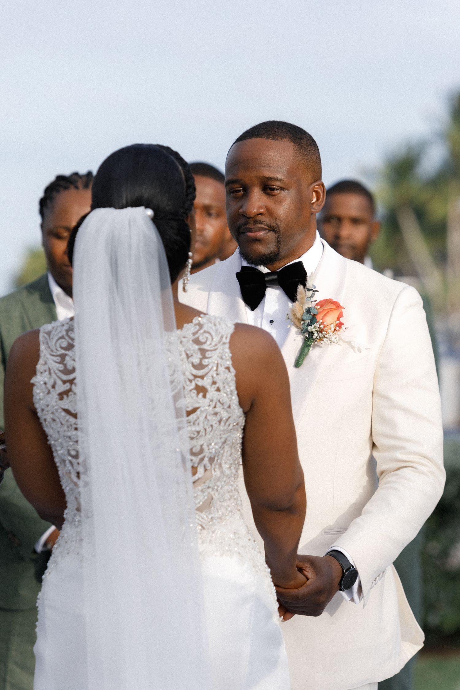 An intimate wedding ceremony moment captured between a couple in elegant white attire.