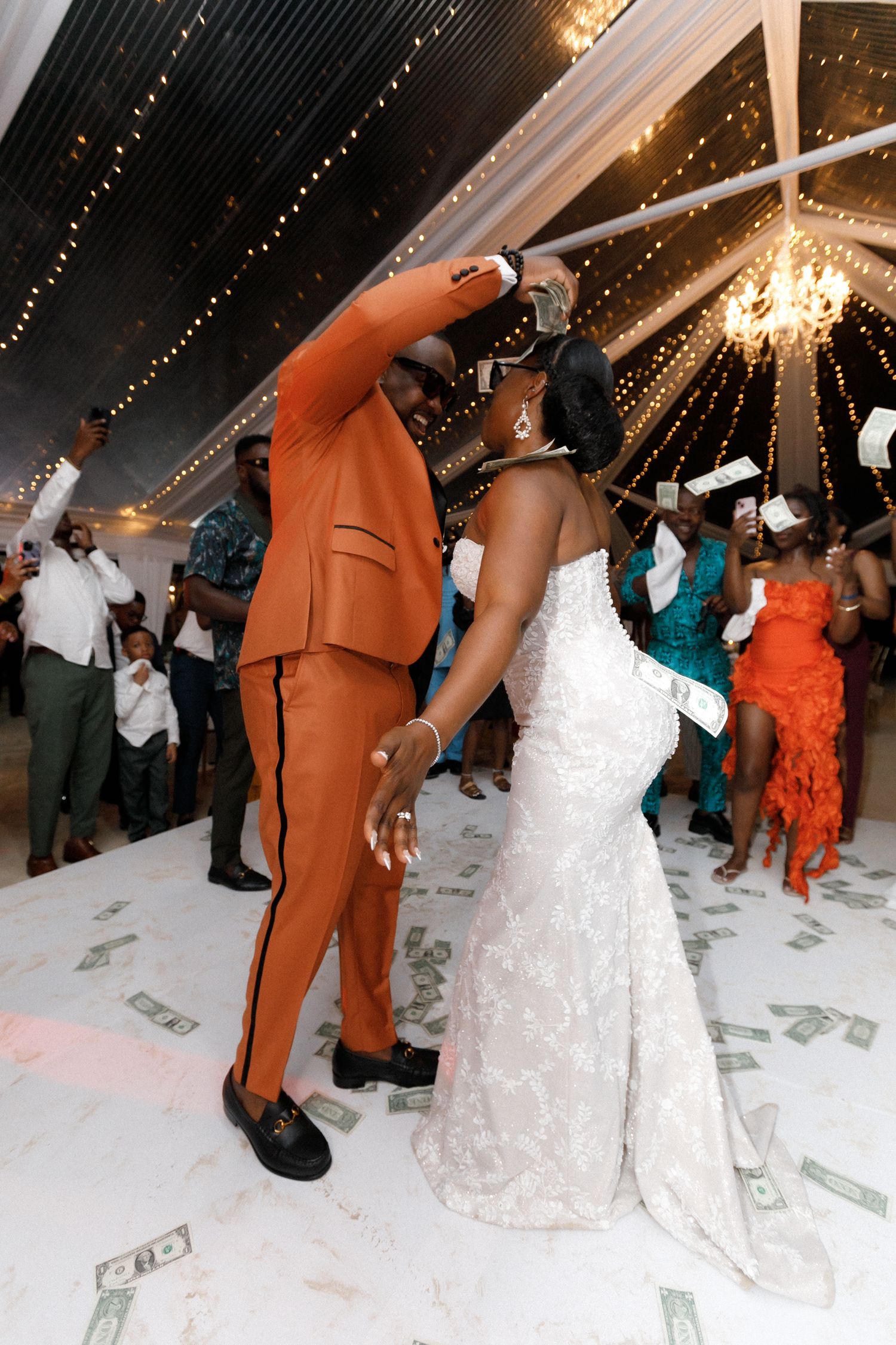 A couple shares an intimate dance moment on a dollar-covered dance floor at their wedding reception.