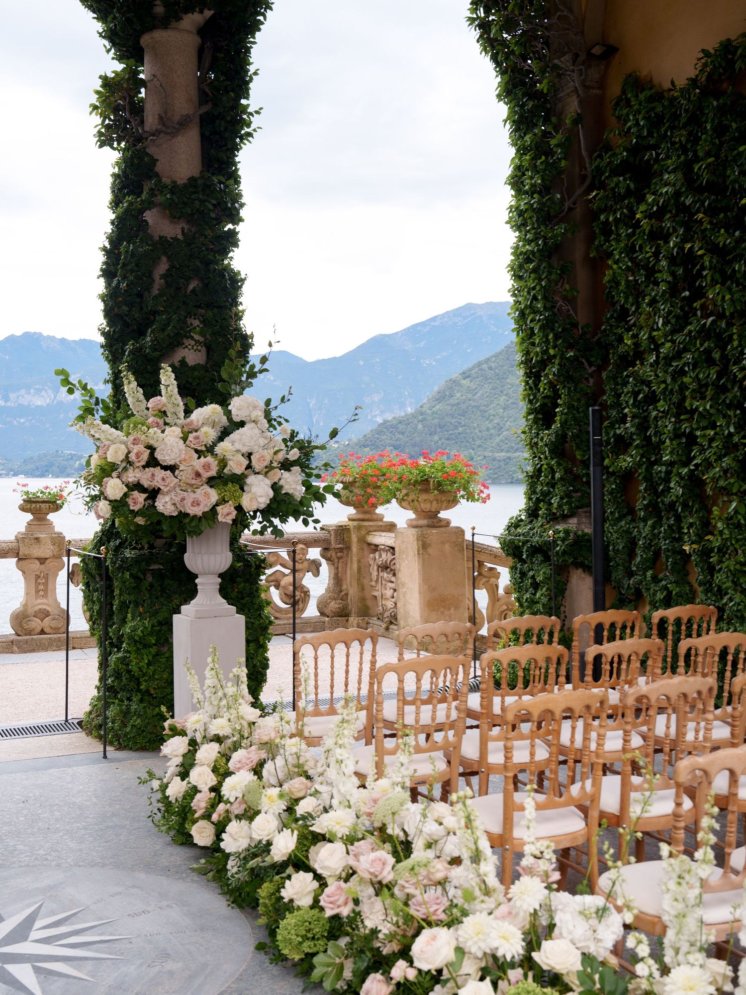 Luxurious outdoor wedding ceremony setup with white floral arrangements and mountain views.