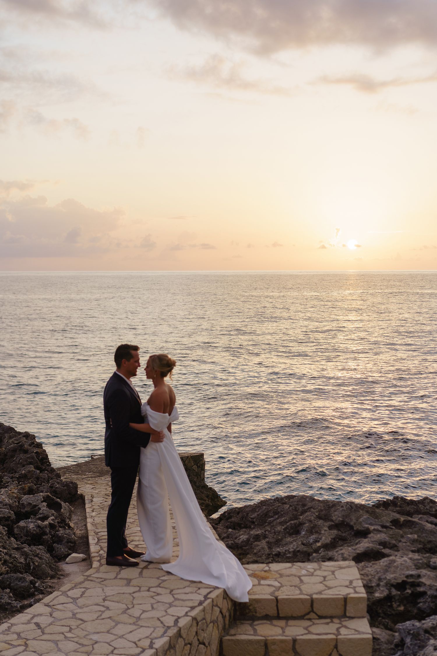 Bride and groom silhouettes at the Negril cliff on the sunset photographed by PhotoMagic Jamaica by Olga Sam
